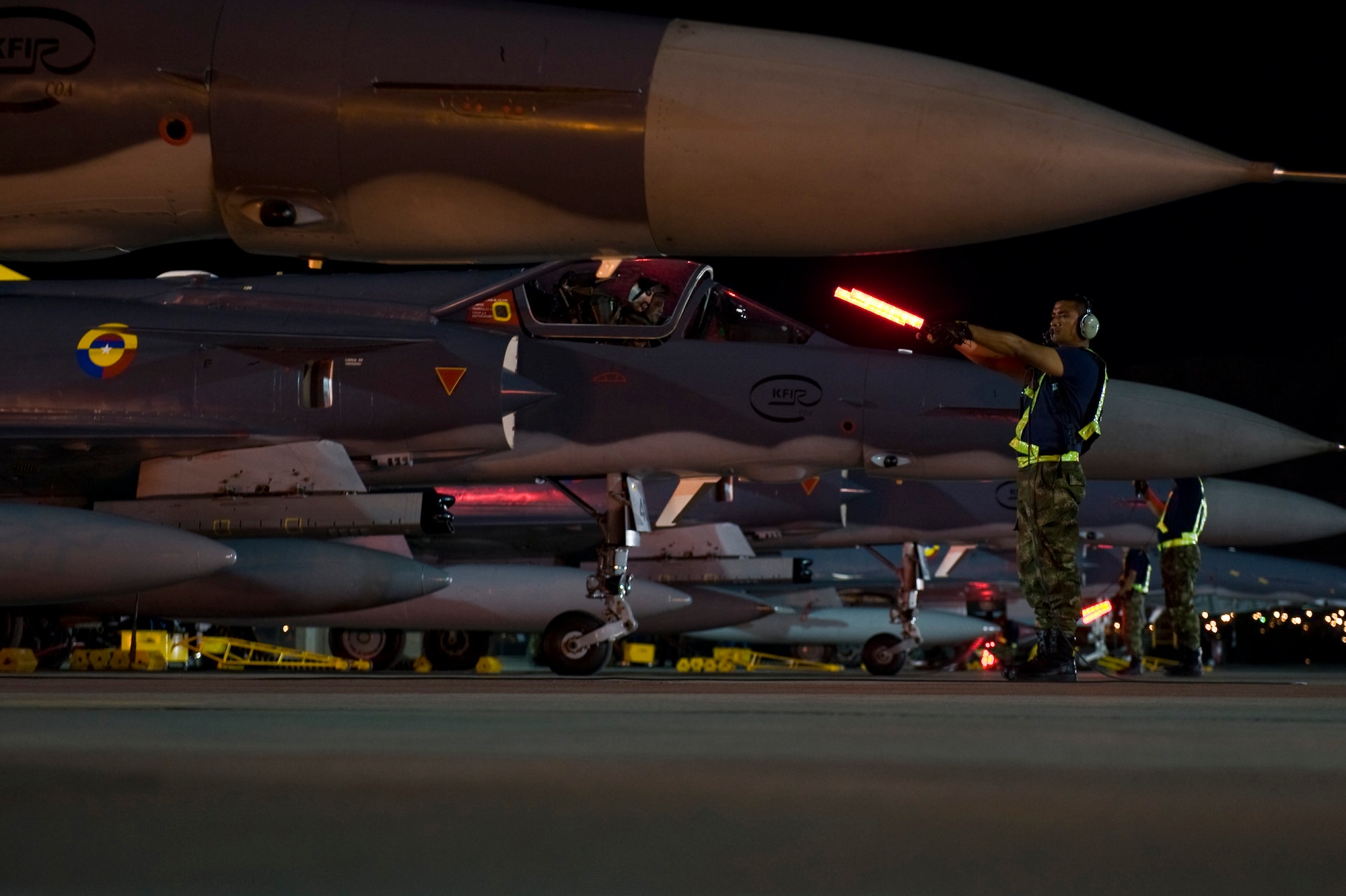 Colombia air force crew chiefs marshal out Colombia Kfir's onto the flight line during Red Flag 12-4 July 24, 2012, at Nellis Air Force Base, Nev. The Colombia air force will get the experience 28 other nations have received since Red Flag began in 1975 while enhancing its interoperability with allies. (U.S. Air Force photo by Airman 1st Class Daniel Hughes)


