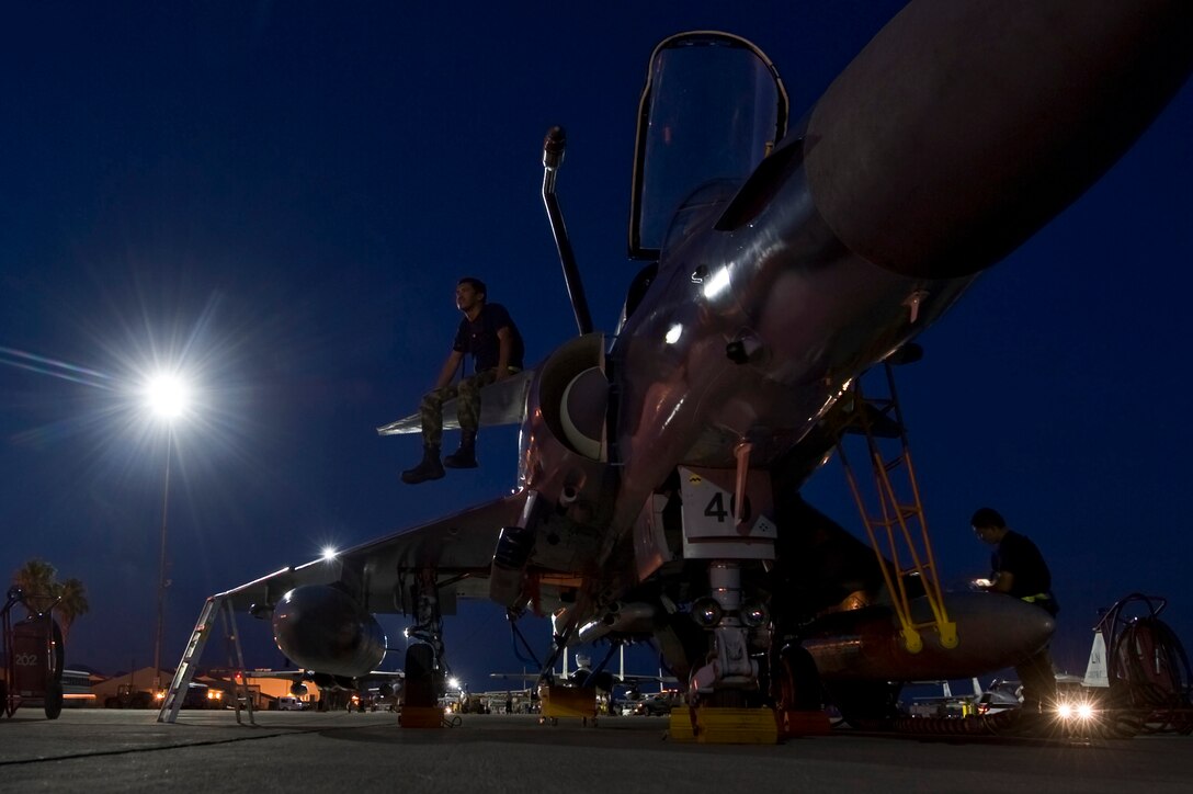 Colombia air force Tech Sgt. Javier Gomez, electronic specialist, sits on the wing of a Kfir before the pilots come for pre-launch inspections during Red Flag 12-4 July 24, 2012, at Nellis Air Force Base, Nev. Military aviation began in Colombia in 1919 with the creation of a military aviation school for the Colombian Army. (U.S. Air Force photo by Airman 1st Class Daniel Hughes)