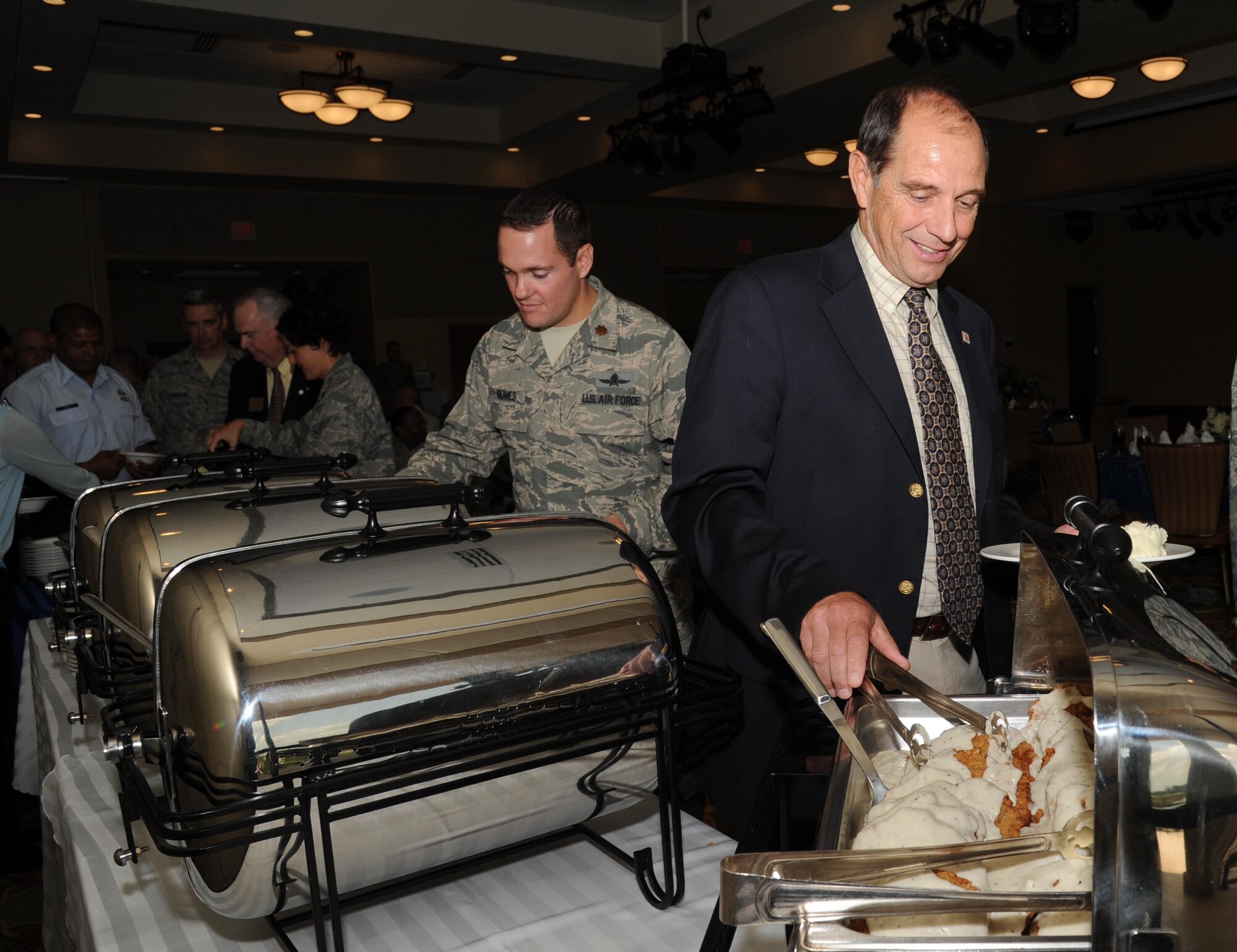 Alec Yasinsac, University of South Alabama Dean of School of Computing, and Maj. Jeffrey Gomes, 85th Engineering and Installation Squadron commander and Armed Forces Communications and Electronics Association Gulf Coast Chapter president, help themselves at the buffet during the AFCEA luncheon July 25, 2012, at the Bay Breeze Event Center, Keesler Air Force Base, Miss.  The Gulf Coast AFCEA chapter also received the model chapter of the year award, which recognizes the top overall chapter structure and program of activities for the year.  (U.S. Air Force photo by Kemberly Groue)