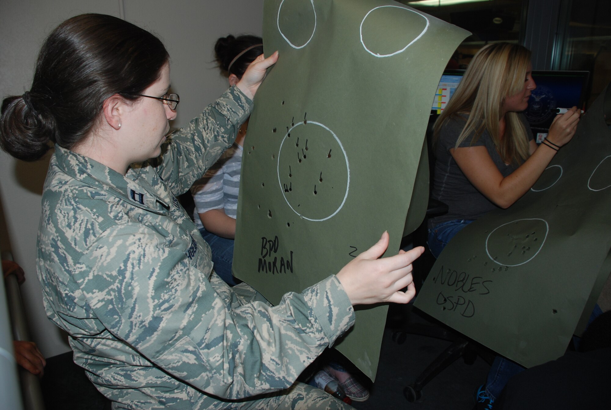 Capt. Sara Rathgeber, 81st Training Wing legal office, validates scoring on targets used during the inaugural Pistol Competition at Keesler's indoor firing range July 20, 2012.  Representatives from Air Force Office of Special Investigations, 81st Security Forces Squadron, Biloxi, Ocean Springs, Gulfport and D'Iberville Police
Departments, the Drug Enforcement Administration and Customs and Border
Protection competed in two rounds of various pistol shootings. Gulfport Police Department won the over-all team award but SFS’s Tech Sgt. Nicholas Tessmer won “Top Shot.” (U.S. Air Force photo/Staff Sgt. Kimberly Rae Moore)
