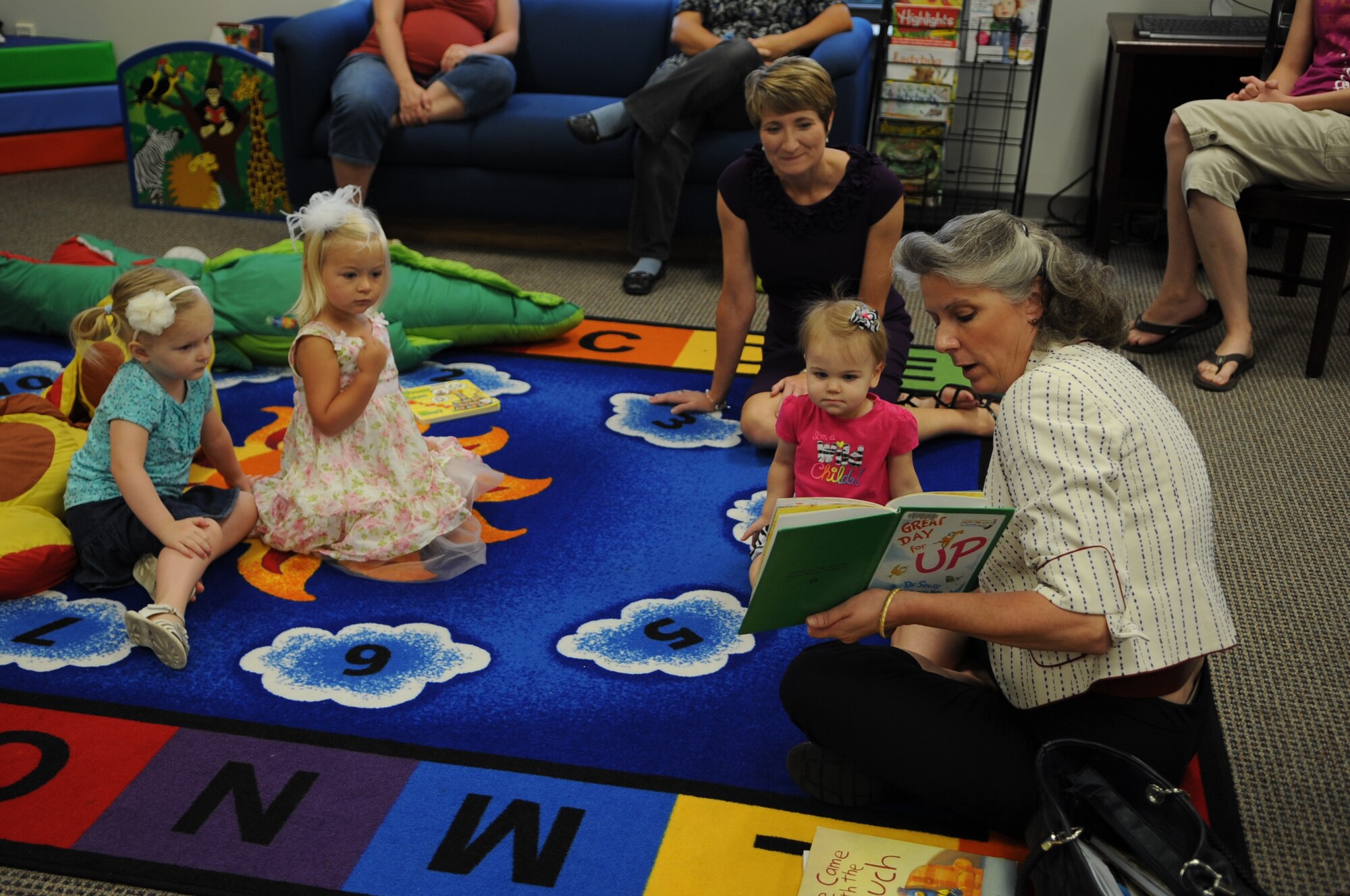 Kathy Wells, spouse of U.S. Air Force Maj. Gen. Lawrence Wells, 9th Air Force commander, reads a book to children at the library on Seymour Johnson Air Force Base, N.C., July 16, 2012. The Wells visited members of Team Seymour to learn more about the 4th Fighter Wing mission and to see what challenges its Airmen and their families encounter. (U.S. Air Force photo/Airman 1st Class Aubrey Robinson/Released)