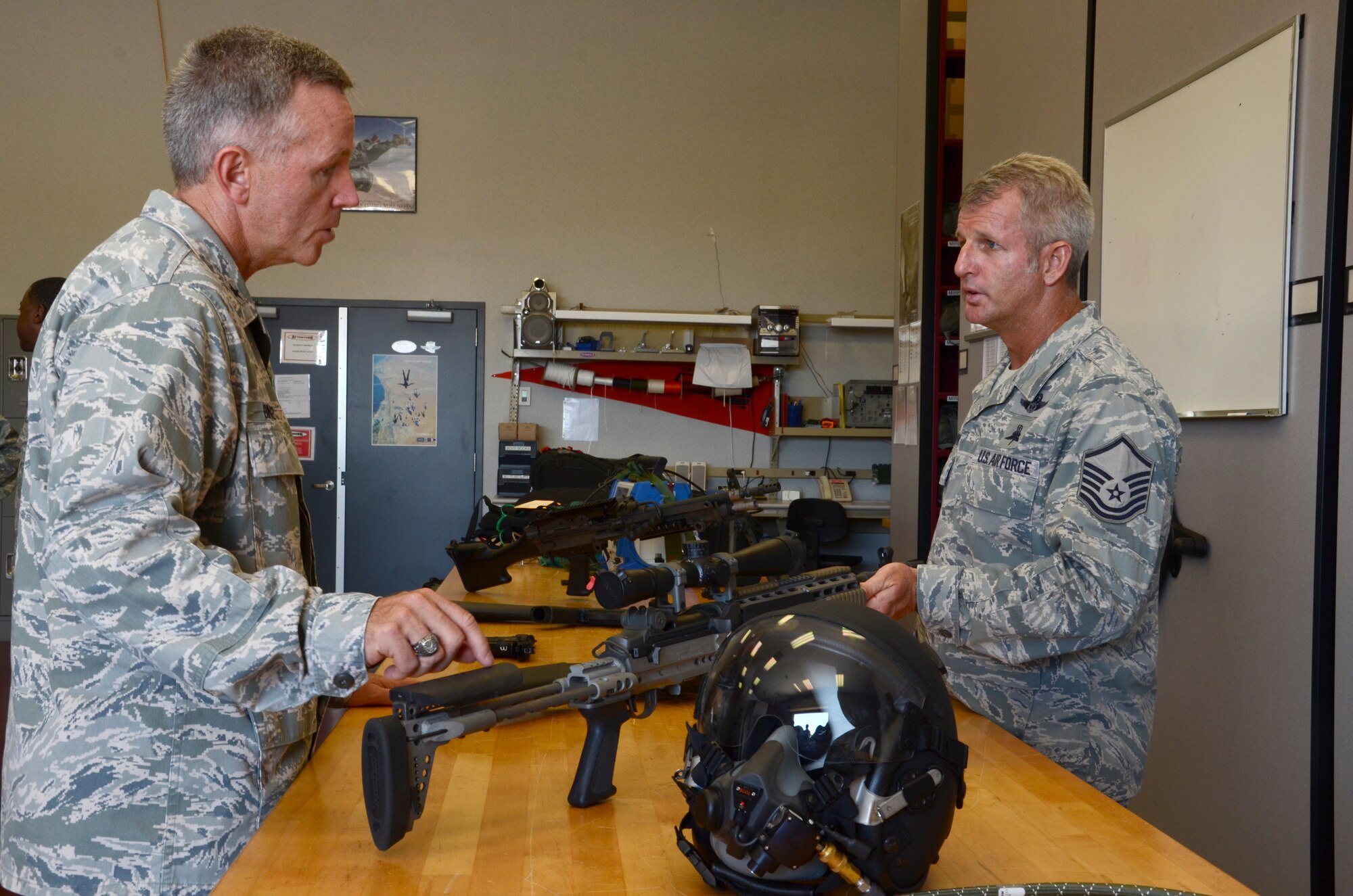 Senior Master Sgt. Chris Seinkner, pararescueman, 308th rescue squadron, enlightens Gen. William Binger, commander, 10th Air Force Naval Air Station Fort Worth Joint Reserve Base, Texas on the  different weapons used by the pararescuemen from the 920th Rescue Wing, Patrick Air Force Base, Fla., Binger spent two days learning about the unique combat-search-and-rescue mission that Airmen here execute. (U.S. Air Force photo/Senior Airman Natasha Dowridge)