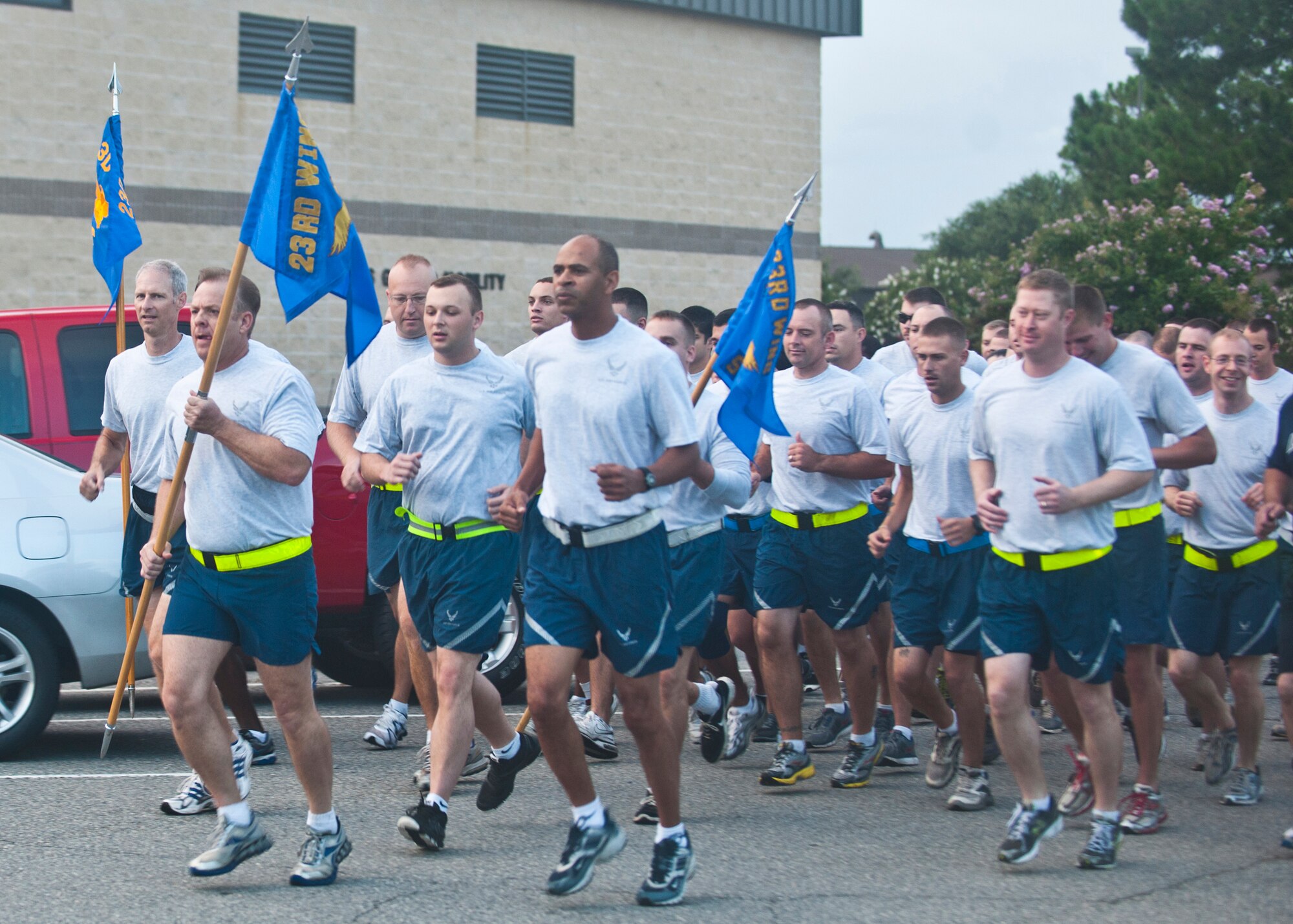 U.S. Air Force Chief Master Sgt. Eddie McAnally, 23d Mission Support Group chief enlisted manager, leads a formation run holding the guidon during the MSG Fun Run July 20, 2012, at Moody Air Force Base, Ga. A fun run will be held every quarter, and squadrons will compete for the “Tiger’s Pride Trophy,” which is awarded to the squadron who can portray the most motivation by shouting and showing spirit. (U.S. Air Force photo by Senior Airman Eileen Meier/Released) 