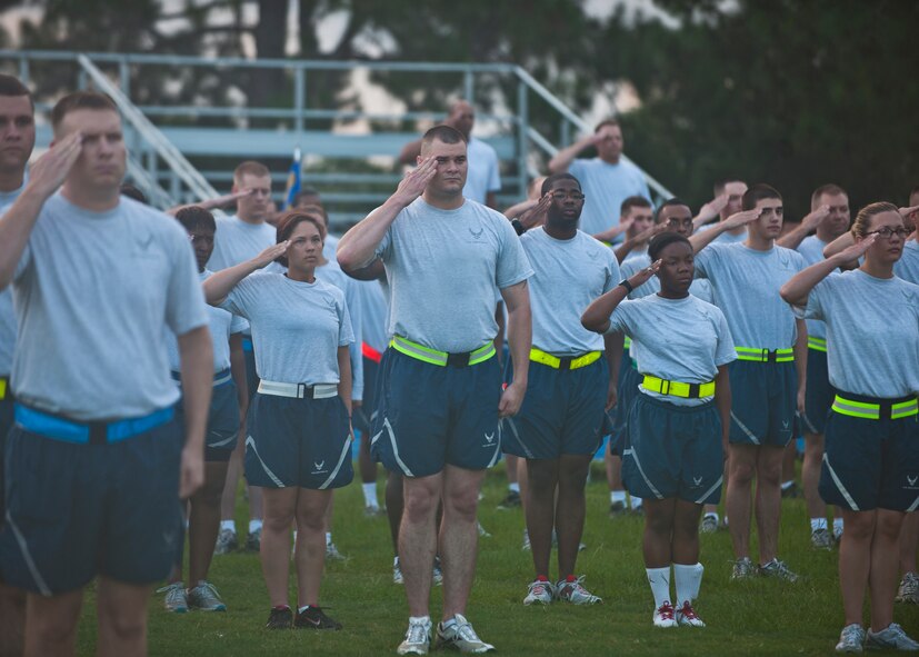 23d Mission Support Group Airmen salute during the playing of reveille prior to an MSG Fun Run July 20, 2012, at Moody Air Force Base, Ga. The group ran 1.1 miles to promote unit morale and fitness.  (U.S. Air Force photo by Senior Airman Eileen Meier/Released)