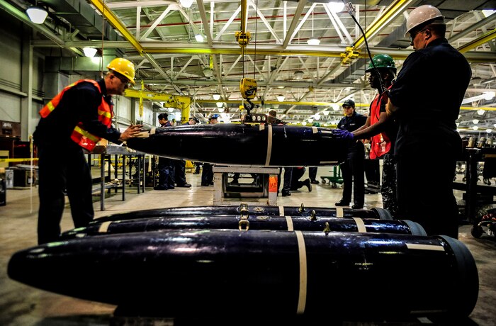 Sailors, who work as mineman in the Navy Munitions Command mine shop, move a training mine from the floor to a table during an exercise July 19, 2012 at Joint Base Charleston – Weapons Station, S.C. The active-duty Sailors in the mine shop are in a deployable status and ready to report to the fleet at any time, where they will maintain and deploy mines aboard aircraft carriers. (U.S. Air Force photo by Senior Airman Dennis Sloan)