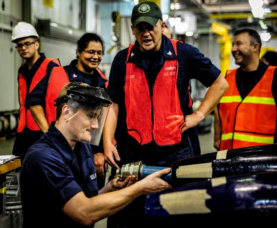 Petty Officer Jarred Hart, Navy Munitions Command mine shop mineman, assembles a training mine during an exercise July 19, 2012 at Joint Base Charleston – Weapons Station, S.C. The active-duty Sailors in the mine shop are in a deployable status and ready to report to the fleet at any time, where they will maintain and deploy mines aboard aircraft carriers. (U.S. Air Force photo by Senior Airman Dennis Sloan)