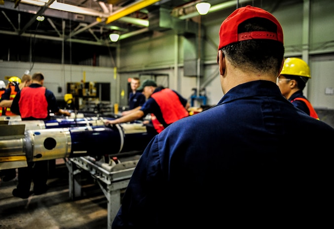 Petty Officer 1st Class William Senseney, Navy Munitions Command mine shop team leader and Navy mineman, grades Sailors in the mine shop, as they exercise the building of a mine July 19, 2012 at Joint Base Charleston –Weapons Station, S.C. The unit is constantly training and performing exercises so the Reserve Sailors can hone their skills. The training and exercises also prepare the active-duty Sailors for their deployments to aircraft carriers. (U.S. Air Force photo by Senior Airman Dennis Sloan)