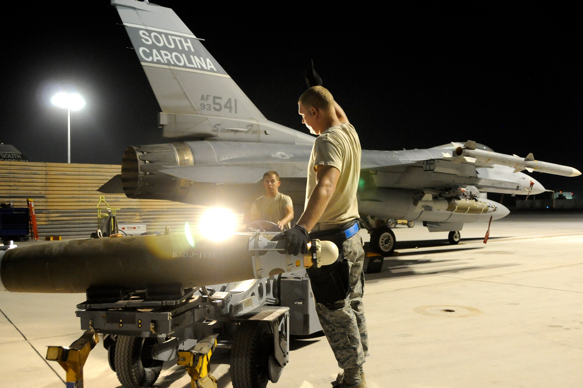 Staff Sgt. Michael Stockslager, a weapons loader with the 451st Expeditionary Aircraft Maintenance Squadron, guides Senior Airman Doug Meadows on a jammer while they load munitions on an F-16 on July 3, 2012. Members of the 169th Fighter Wing at McEntire Joint National Guard Base, S.C., are deployed to KAF in support of Operation Enduring Freedom. Swamp Fox F-16's, pilots, and support personnel began their Air Expeditionary Force deployment early April to take over flying missions for the air tasking order and provide close air support for troops on the ground in Afghanistan. (U.S. Air Force photo/Tech. Sgt. Stephen Hudson)