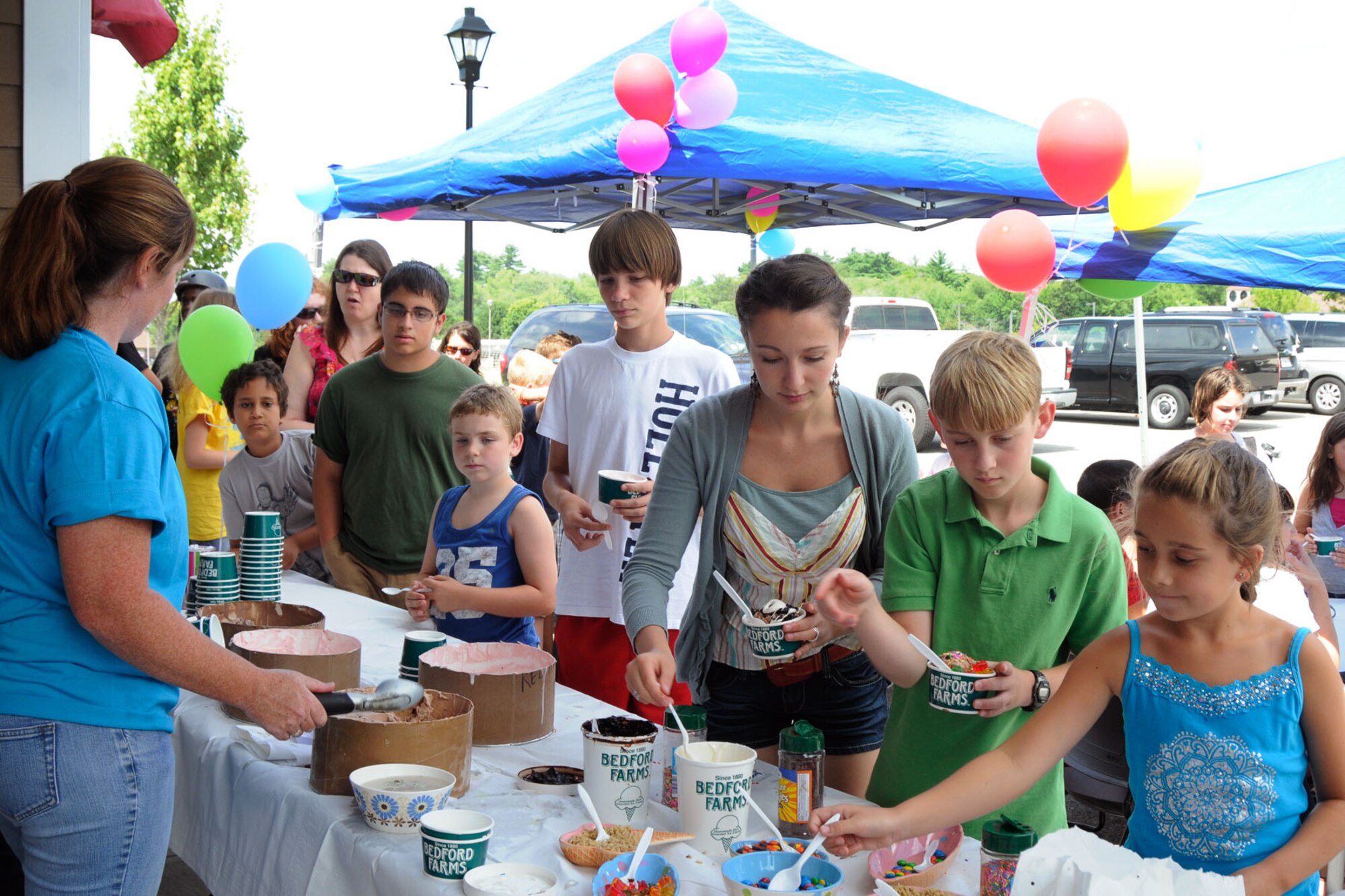 HANSCOM AIR FORCE BASE, Mass. – Housing residents gather at the Hanscom Family Housing leasing office to indulge in their favorite ice cream flavors and toppings during an ice cream social July 19. More than 250 residents showed up to enjoy the cool treats on a hot day. (U.S. Air Force photo by Linda LaBonte Britt)