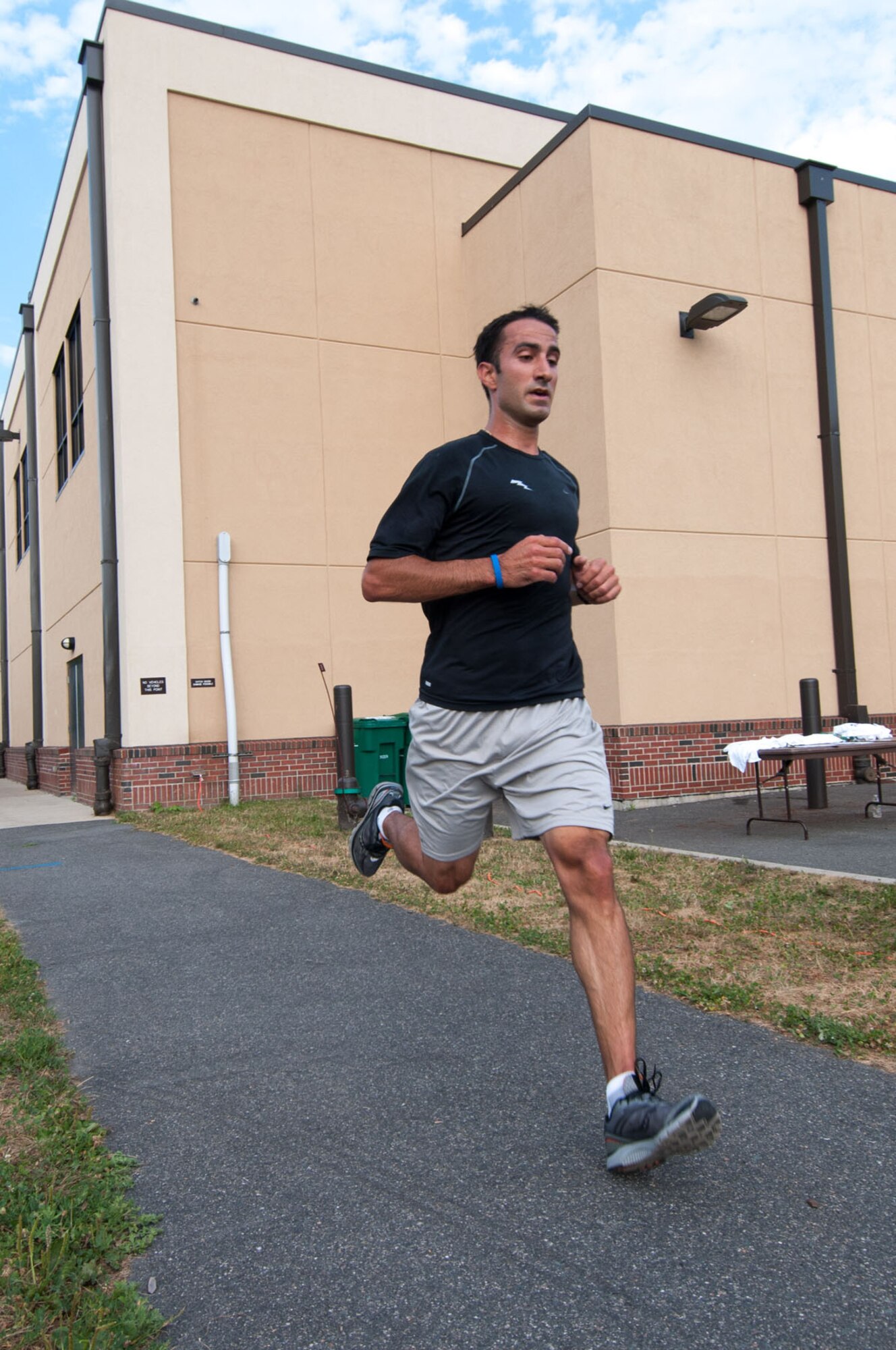 HANSCOM AIR FORCE BASE, Mass. – Capt. Brian Gineo crosses the finish line as the top male finisher with a time of 17 minutes and 44 seconds during the Fitness Center’s Firecracker 5K Fun Run July 21. Kristy James, the first female finisher, finished with a time of 21 minutes and 58 seconds. (U.S. Air Force photo by Rick Berry)