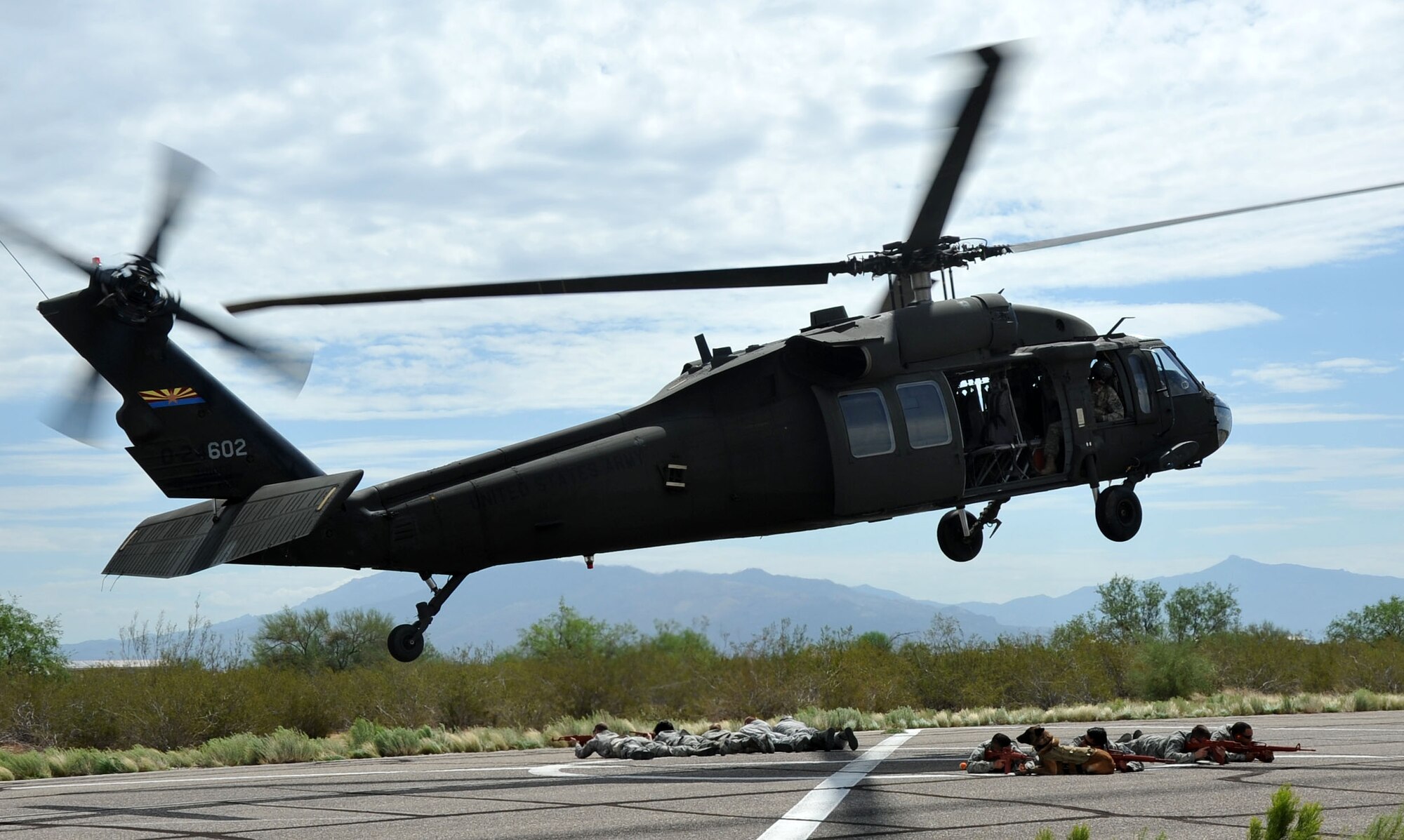 Students take up defensive positions after exiting an Arizona Army National Guard UH-60 Black Hawk helicopter during a training exercise that prepared them to safely manauver around helicopters in a deployed environment. Volunteer students from all brances of service stationed at Davis Monthan Air Force Base, Ariz. took part in the training exercise. (U.S. Air Force photo/ Master Sgt. Luke Johnson)