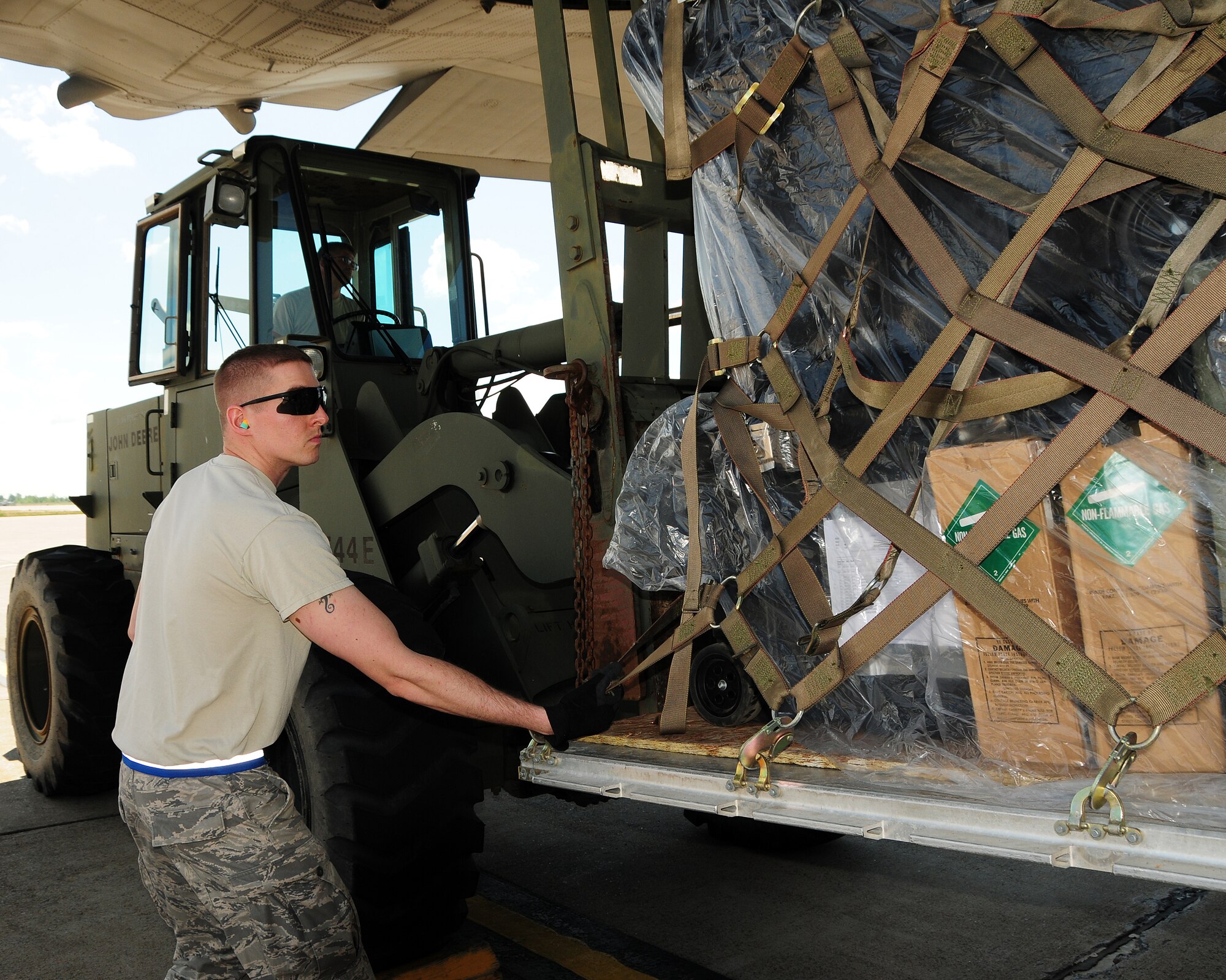 Staff Sgt. David Sebastiano, 30th Aerial Port Squadron Air Transportation Specialist safely assists with the downloading of palletized equipment and assets onto a forklift driven by Senior Master Sgt. Eric Bruggman, 30th APS Ramp Flight Chief at the Niagara Falls Air Reserve Station on July 25, 2012. Sebastiano and other members of his squadron helped unload the last C-130 aircraft to arrive from the recent successful Operational Readiness Inspection (ORI) at Alpena, Michigan. (U.S. Air Force photo by Peter Borys)