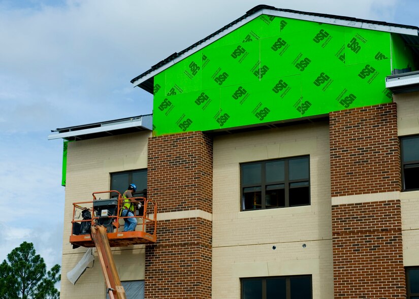 A construction worker installs a window on one of the new, eco-friendly Warrior in Transition campus building’s, July 12, 2012, at Fort Eustis, Va. The Warrior Transition Complex will consist of three primary facilities: a 43,200 square-foot barracks capable of housing 80 Soldiers, a 16,600 square-foot company administration building that will provide office space for 76 people, and a 7,000 square-foot Soldier and Family Assistance Center. (U.S. Air Force photo by Senior Airman John D. Strong II / released)