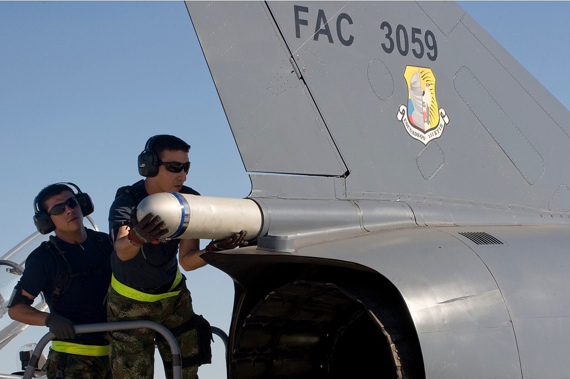 Colombian air force Junior Technicians Jhonatan Galvez and Jesus Ovalle install a  drag chute for a Kfir fighter jet during Red Flag 12-4 July 17, 2012, at Nellis Air Force Base, Nev. Red Flag is a realistic combat training exercise involving the air forces of the United States and its allies. (U.S. Air Force photo by Airman 1st Class Matthew Lancaster)
