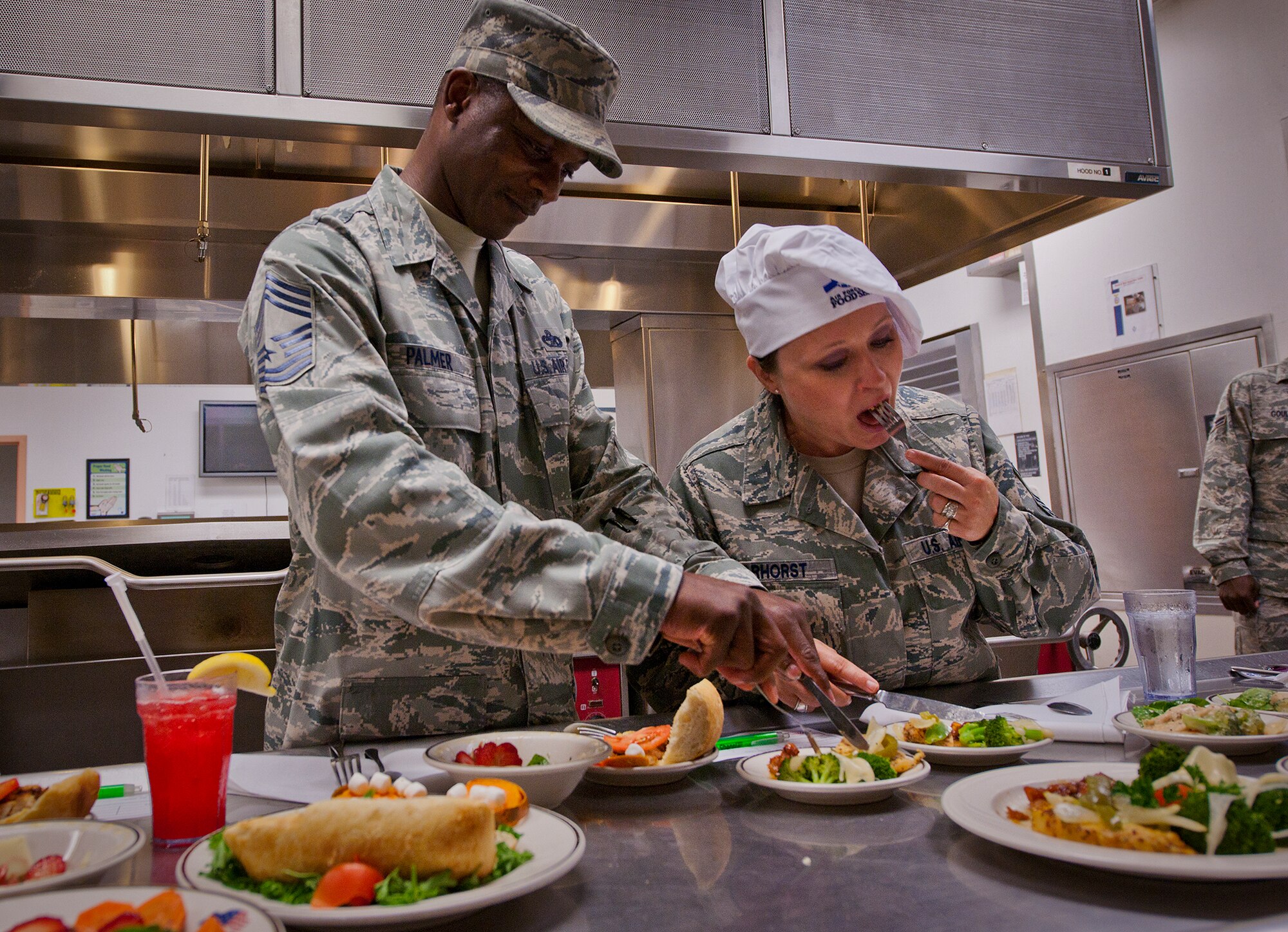 Judges, Chief Master Sgt.s Curtis Palmer and Dorenda Barhorst, sample the meals to determine a winner of the base’s first “Chopped” cooking competition July 24 at Eglin.  Five Airmen from the 96th Force Support Squadron had an hour to cook a meal with three secret ingredients.  (U.S. Air Force photo/Samuel King Jr.)