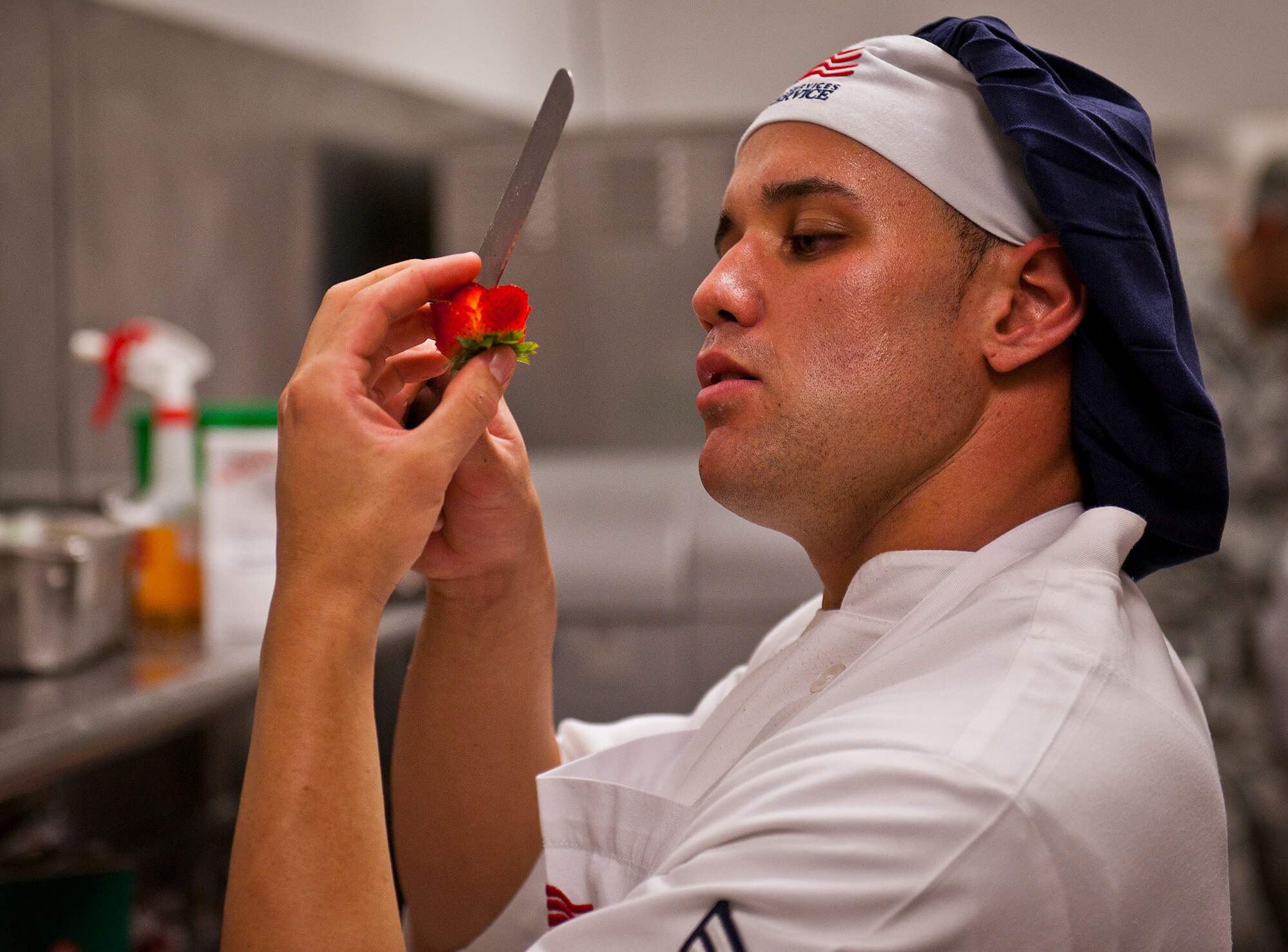 Airman 1st Class Giancarlo Martini cuts a decorative pattern into a strawberry during his meal preparation for the base’s first “Chopped” cooking competition July 24 at Eglin.  Five Airmen from the 96th Force Support Squadron had an hour to cook a meal with three secret ingredients.  Martini placed second in the competition.  (U.S. Air Force photo/Samuel King Jr.)