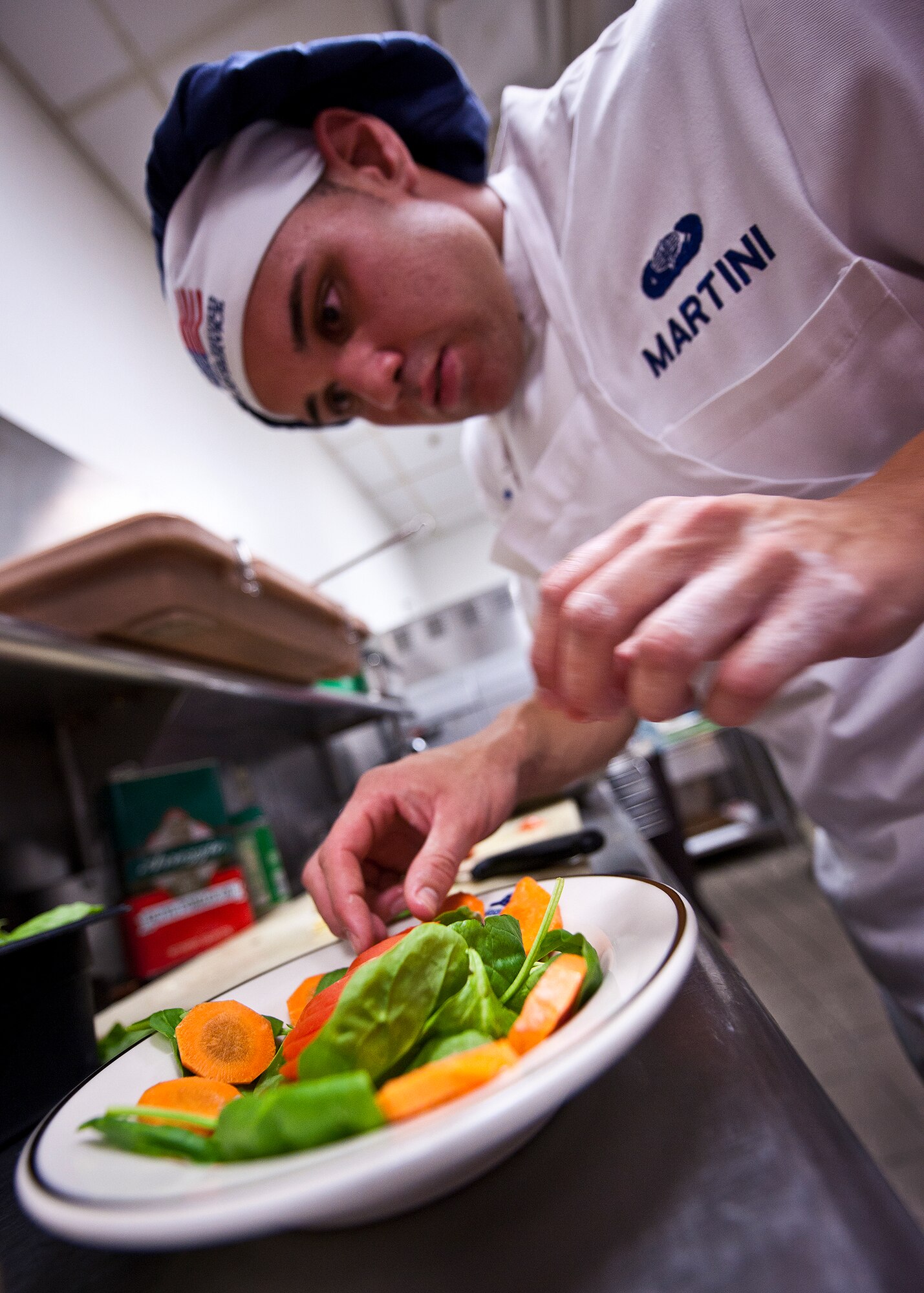 Airman 1st Class Giancarlo Martini arranges his salad plate during his meal preparation for the base’s first “Chopped” cooking competition July 24 at Eglin.  Five Airmen from the 96th Force Support Squadron had an hour to cook a meal with three secret ingredients.  Martini placed second in the competition.  (U.S. Air Force photo/Samuel King Jr.)