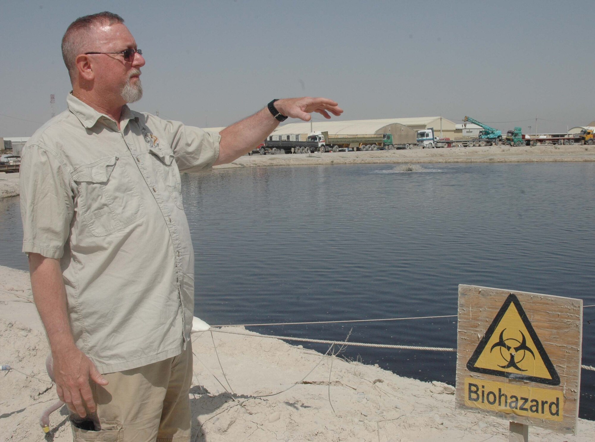 Tim Blevins, an environmental specialist for Kandahar Airfield, explains on Monday how the black water retention pond on the airfield, better known as Poo Pond, will be drained and capped in the near future. When KAF’s Deep South Waste Water Treatment Plant begins operating at 100 percent capacity within the next year, Poo Pond will become obsolete and its unpleasant odor just a foul memory. (U.S. Army photo/Sgt. 1st Class Erick Studenicka)