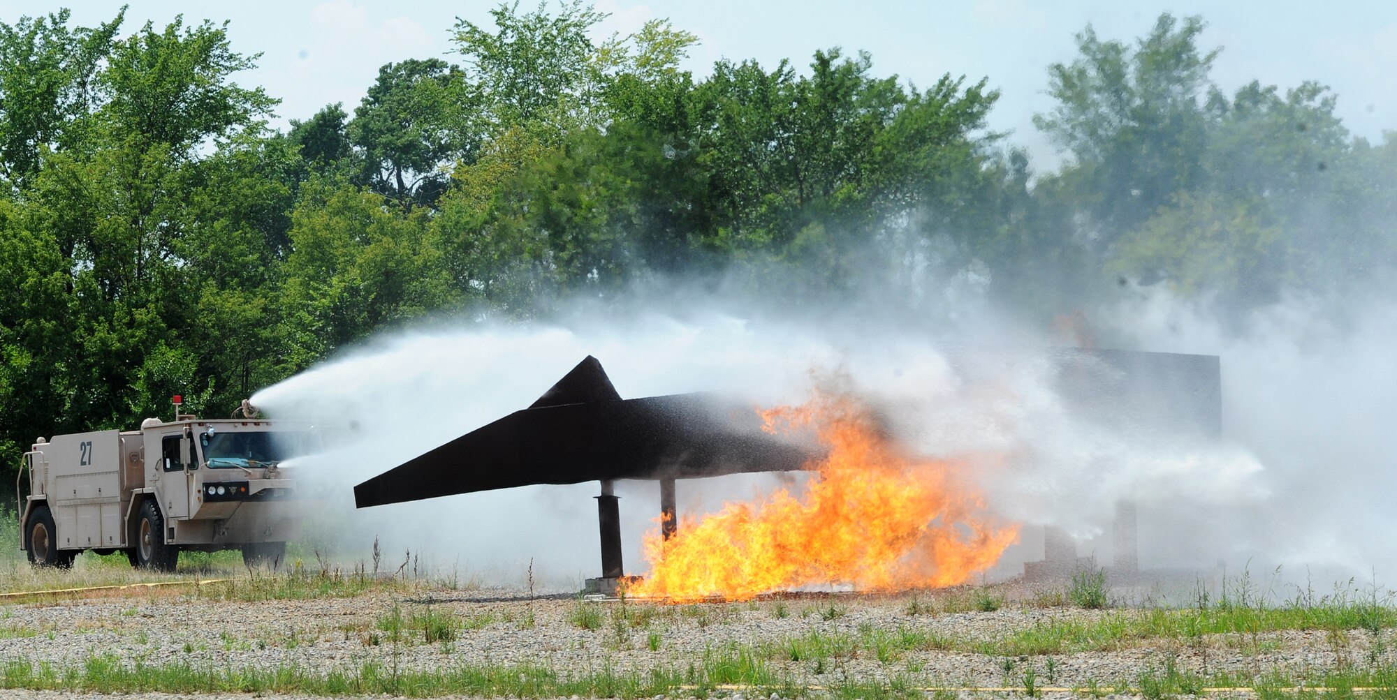 633rd Civil Engineer Squadron fire fighters participate in a simulated plane crash to test technology’s impact on emergency response for the Joint Forces Experiment, July 18, 2012, at Langley Air Force Base, Va. The experiment used realistic scenarios to measure the capabilities of new and emerging technology with emergency-response teams from the base and surrounding area. (U.S. Air Force photo by Airman 1st Class Teresa Cleveland/Released)