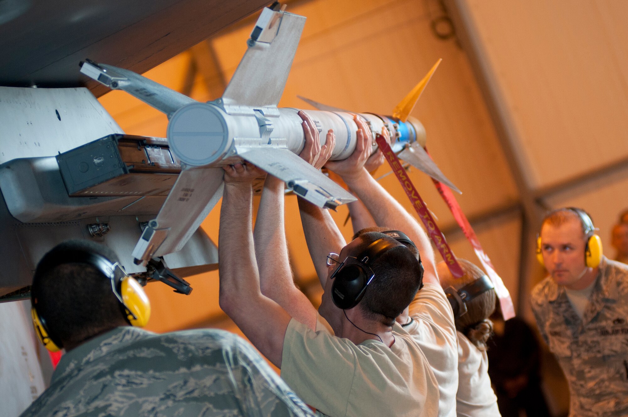 ROYAL AIR FORCE LAKENHEATH, England – The 492nd Aircraft Maintenance Unit load team load an Air Intercept Missle 9x munition during the Load Crew of the Quarter Competition July 20, 2012. The quarterly competition features the best load crew teams from the 492nd, 493rd and 494th Aircraft Maintenance Units. The winner is determined by the fastest time loading munitions with the least amount of errors. (U.S. Air Force photo by Airman 1st Class Cory D. Payne)