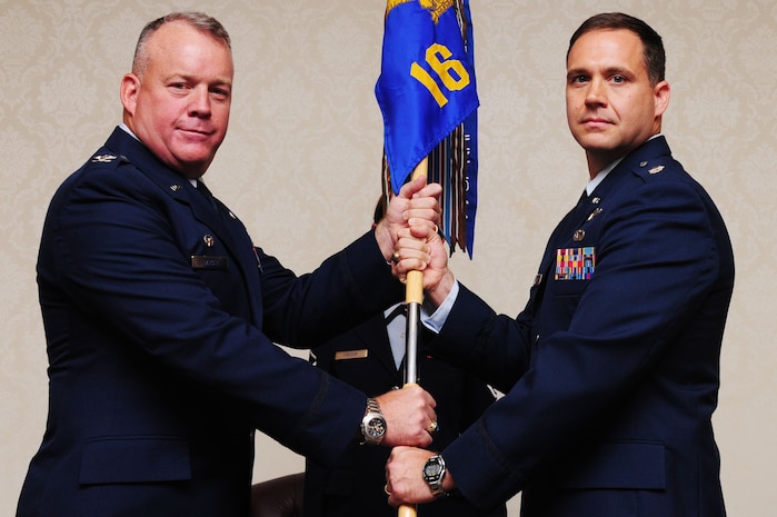 Colonel Erik Hansen, 437th Airlift Wing commander, passes the squadron guidon to Lt. Col. Stewart Newton, 16th Airlift Squadron commander, 437th AW, during the 16th AS Change of Command ceremony, July 23, 2012, at Joint Base Charleston - Air Base, S.C. The passing of the guidon symbolizes the changing of a command. (U.S. Air Force photo/ Airman 1st Class Chacarra Walker)