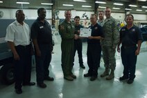 Terrance Alexander, 47th Maintenance Directorate machinist, poses with Col. Tom Murphy, 47th Flying Training Wing commander, and Chief Master Sgt. Garry Berry, 47th FTW command chief, after being presented the XLer of the week award at Laughlin Air Force Base, Texas, July 18, 2012. The XLer is a weekly award chosen by wing leadership and given to those who consistently make outstanding contributions to Laughlin and their unit. (U.S. Air Force photo/Airman 1st Class Nathan Maysonet)