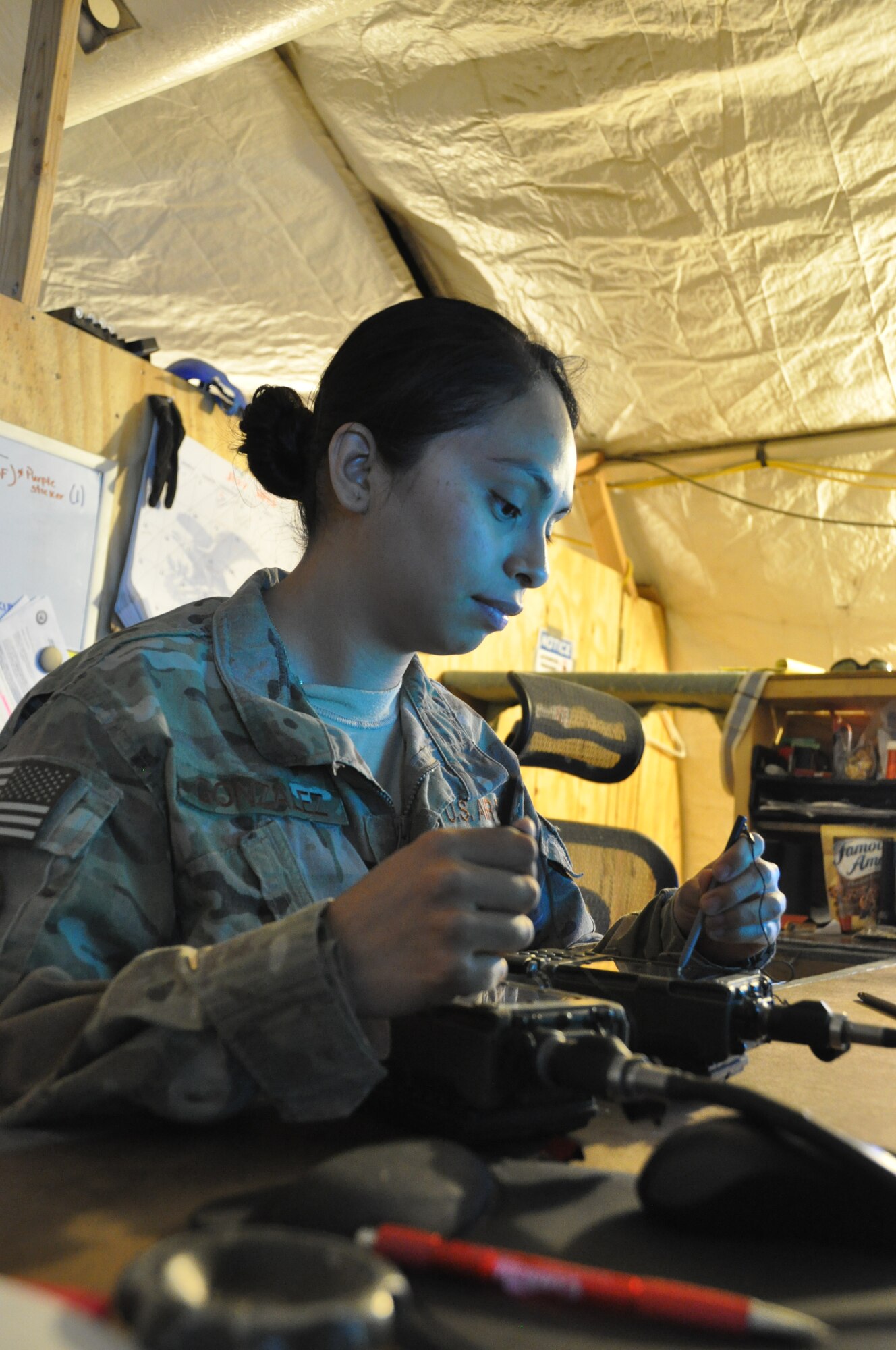 SSgt Janet Gonzalez, NCOIC of Crew Communications with 4th Expeditionary Reconnaissance Squadron at Bagram Airfield, Afghanistan, checks one of several communication devices prior to their use during an MC-12 mission. Gonzalez is one of several 4 ERS Airmen performing different jobs than their normal home station duties. She said the new experience helped her appreciate the importance of each small part of the 4 ERS mission. (U.S. Air Force photo/TSgt Shawn McCowan)