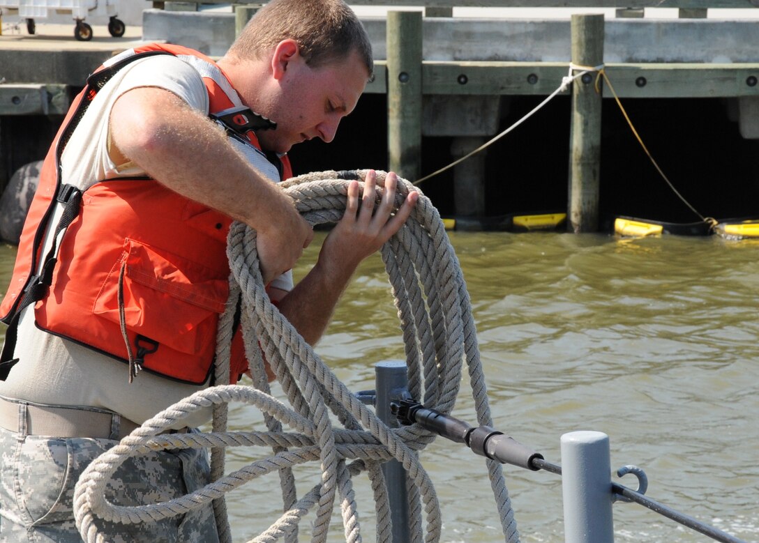 U.S. Army Pvt. Eric Bissette, a reservist assigned to the 464th Transportation Company (Medium Boat) from Fort Belvoir, Va., prepares to deploy dock lines during Operation Dragon Wave at Fort Eustis, Va., July 24, 2012. Bissette was among the more than 200 reservists participating in the exercise. (U.S. Air Force photo by Senior Airman Jason J. Brown/Released)