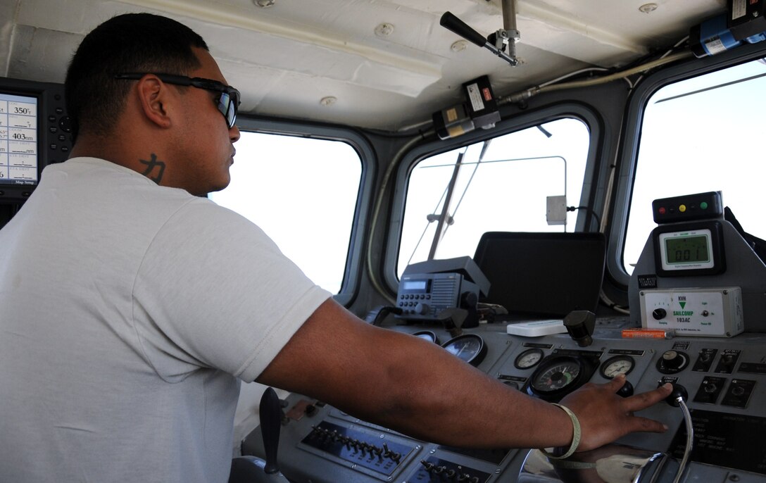 U.S. Army Spc. Julio Armando Martinez, a reservist assigned to the 464th Transportation Company (Medium Boat) from Fort Belvoir, Va., controls the LCM-8596, a landing-craft-mechanized, from the pilothouse along the James River during Operation Dragon Wave at Fort Eustis, Va., July 24, 2012. Upon completion of the exercise, Martinez will be a certified vessel master, capable of operating any vessel of the same class without supervision. (U.S. Air Force photo by Senior Airman Jason J. Brown/Released)