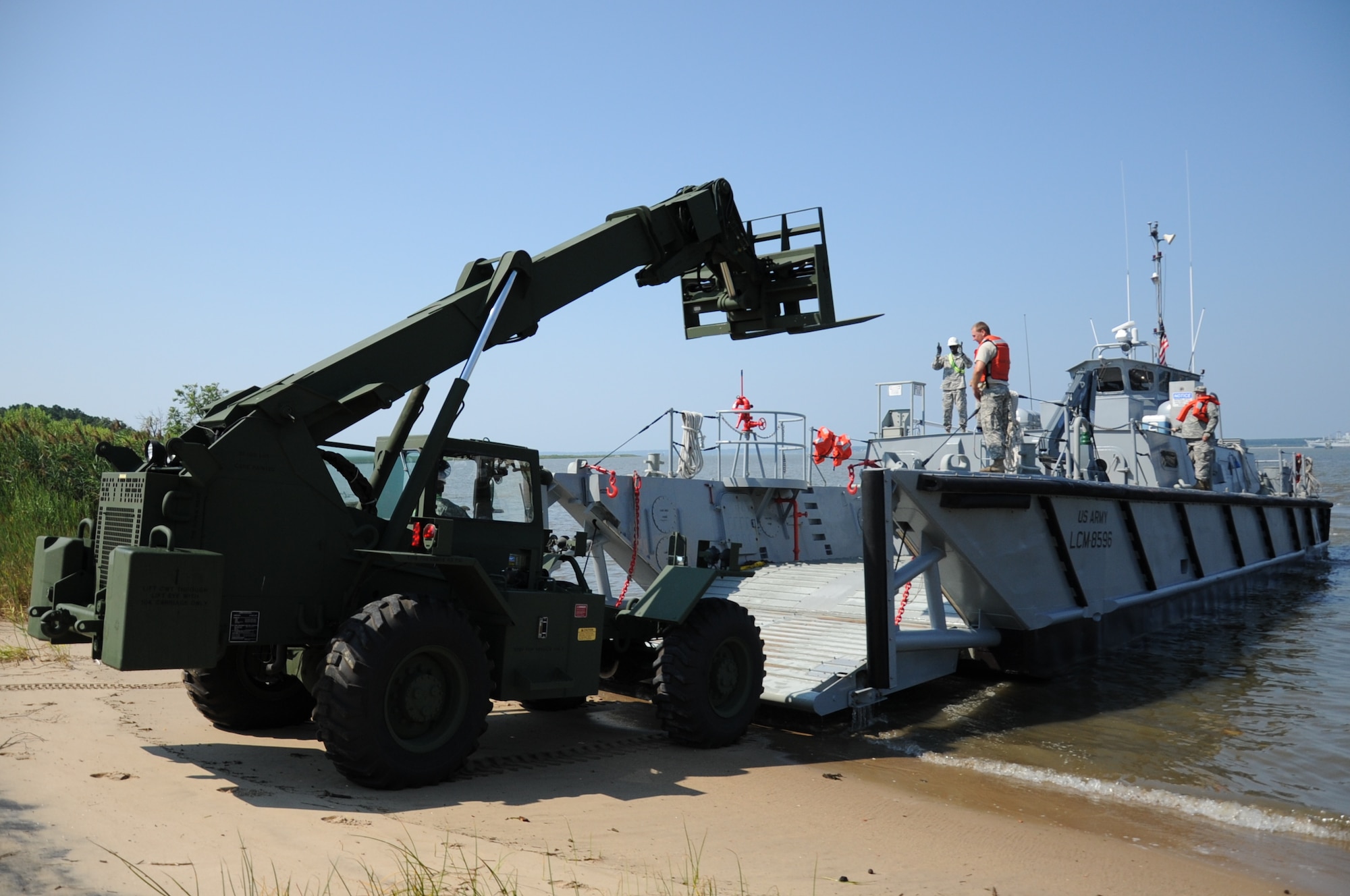 Soldiers from the U.S. Army Reserve's 464th Transportation Company (Medium Boat) from Fort Belvoir, Va., unload a sky lift from LCM-8596, a landing-craft-mechanized, at Utah Beach during Operation Dragon Wave at Fort Eustis, Va., July 24, 2012. During the exercise, more than 200 reservists provided Logistics-Over-the-Shore support to the fictitious Combined Joint Task Force Sumatra, charged with assisting the government of Indonesia in overcoming an insurrection of the island of Sumatra. (U.S. Air Force photo by Senior Airman Jason J.
Brown/Released)