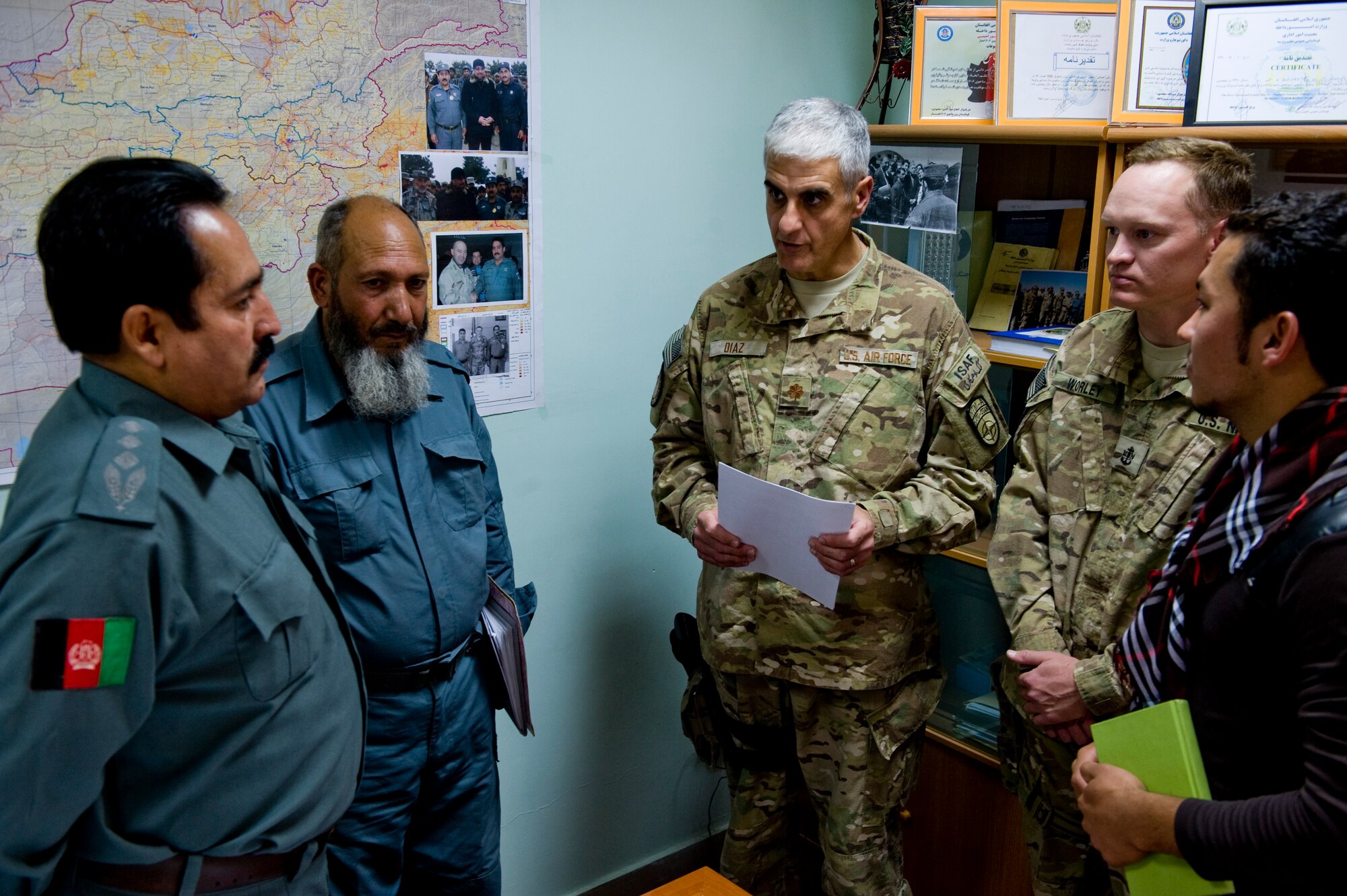 U.S. Air Force Maj. Jose Diaz and U.S. Navy Chief Petty Officer Timothy Worley, preventive medicine mentors with the Joint Medical Operations Cell, talk to Afghan National Police Col. Abdiani Toryaiai after his signing of the first official food safety directive for the country, Herat, Afghanistan, July 15, 2012. The food safety directive gives a baseline to the Afghan military so they are able to perform inspections on food facilities. (U.S. Air Force photo by Staff Sgt. Greg C. Biondo)(Released)