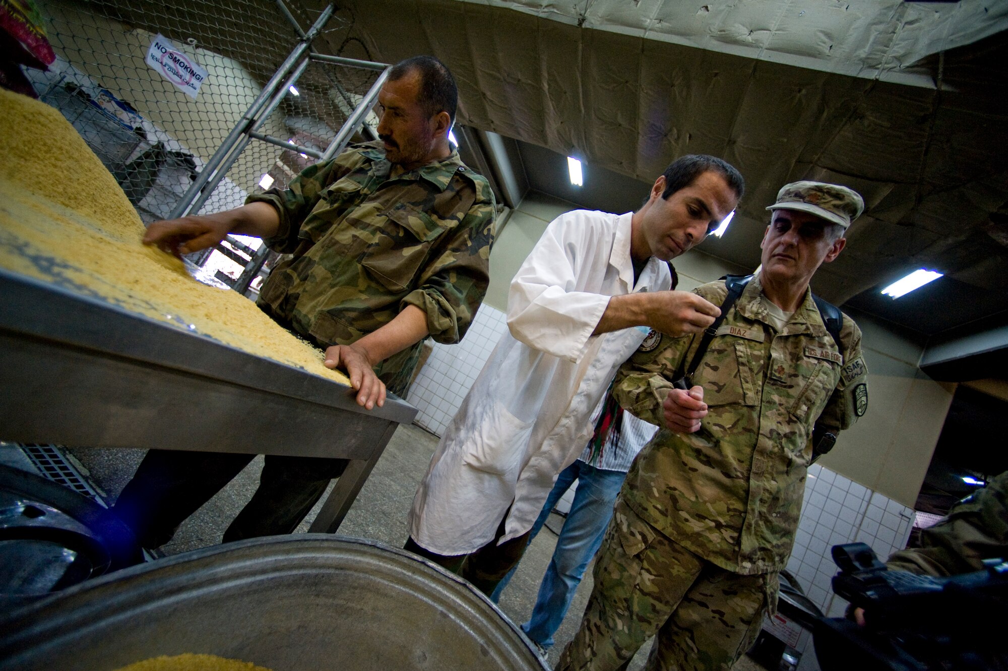 U.S. Air Force Maj. Jose Diaz, a preventive medicine mentor with the Joint Medical Operations Center, inspects grains of rice during an inspection of an Afghan military dining facility, Camp Stone, Afghanistan, July 14, 2012. The JMOC assists Afghans in developing a sustainable medical support system. (U.S. Air Force photo by Staff Sgt. Greg C. Biondo)(Released)