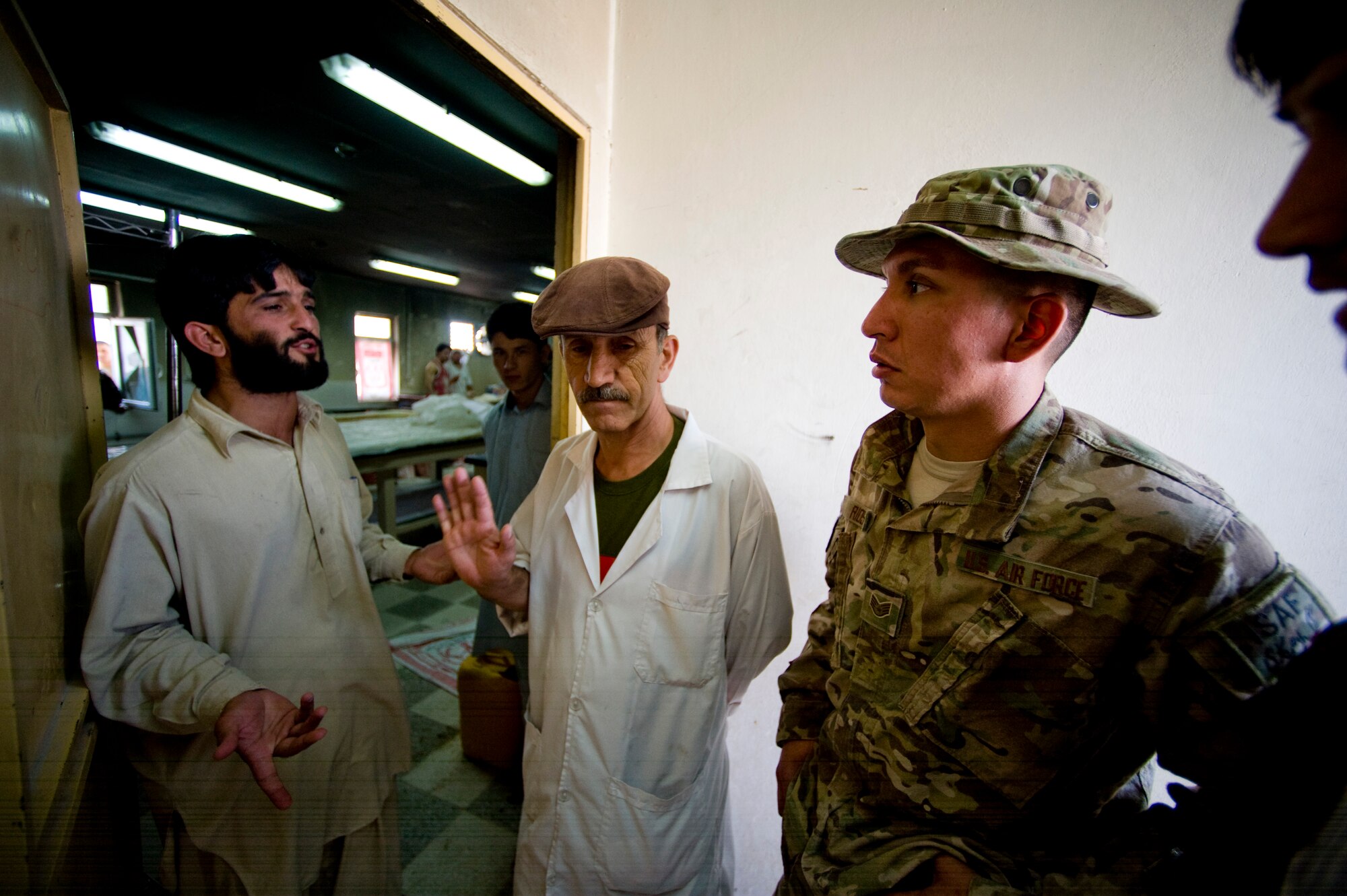 U.S. Air Force Staff Sgt. Anthony Rios, a preventive medicine mentor with the Joint Medical Operations Center, listens to the manager of an Afghan bakery during an inspection, Camp Stone, Afghanistan, July 14, 2012. The JMOC assists Afghans in developing a sustainable medical support system. (U.S. Air Force photo by Staff Sgt. Greg C. Biondo)(Released)