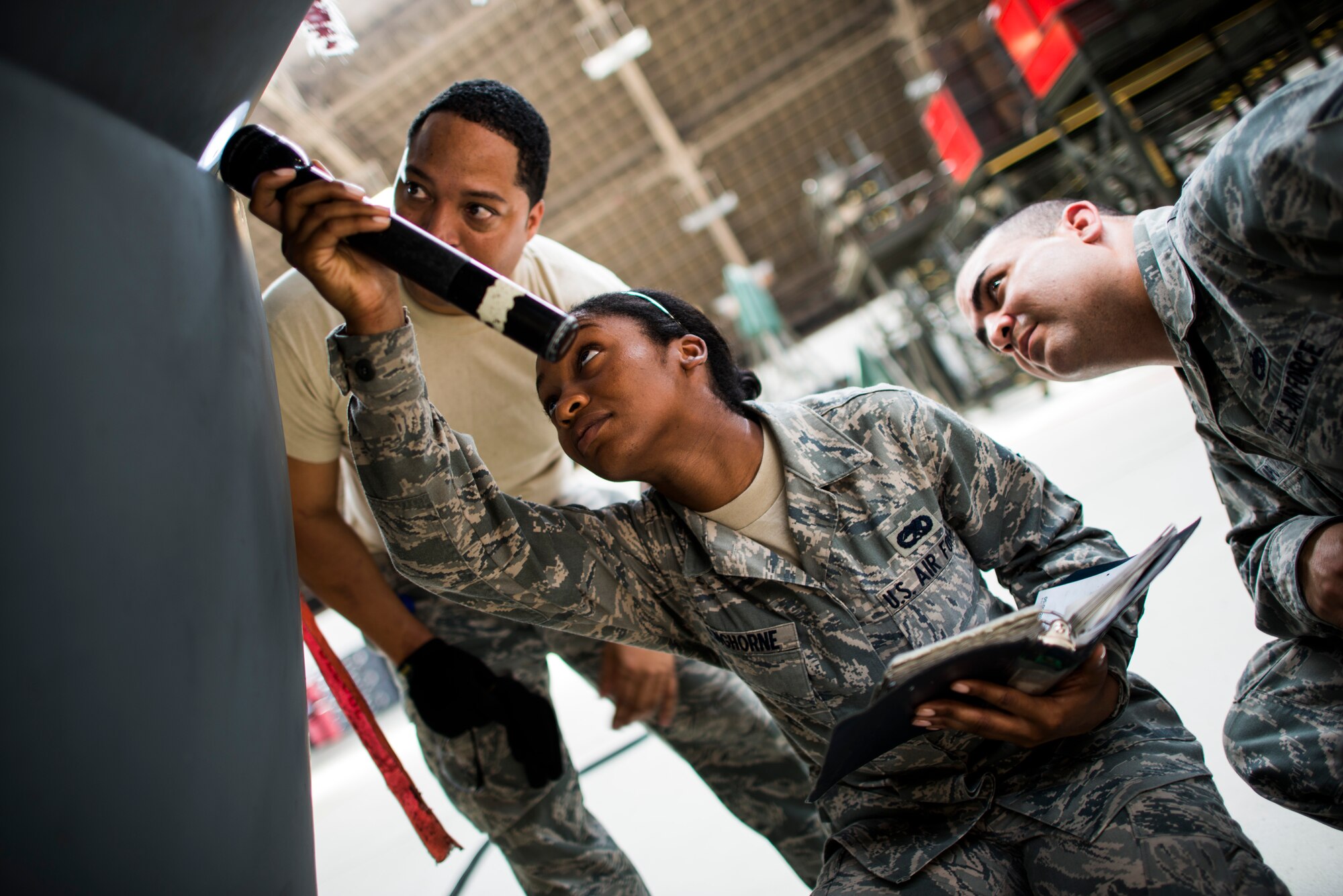 YOKOTA AIR BASE, Japan -- Staff Sgt. Galen Apo, right, 374th Maintenance Group quality assurance inspector, evaluates Airman 1st Class Laketa Kinghorne, center, 374th Maintenance Group communications and navigation systems apprentice, while she visually inspects the radome of a C-130 Hercules at Yokota Air Base, Japan, July 25, 2012. The QA section was recently evaluated during a Logistics Compliance Assessment Program Inspection and received a 100 percent pass rating. (U.S. Air Force photo/Tech. Sgt. Samuel Morse)