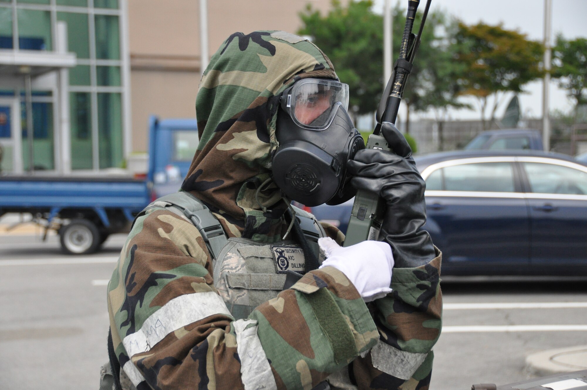 Airman 1st Class Kyle Dilling, 51st Security Forces Squadron member, radios in for backup while putting on his mission oriented protective posture gear during a missile attack part of operational readiness exercise Beverly Midnight 12-03 at Osan Air Base, Republic of Korea, July 25, 2012. Throughout the week, Osan Mustangs demonstrate the ability to operate in a chemical environment as well as administer self-aid and buddy-care during a wartime environment. Airmen also highlight their ability to position, employ, and sustain forces and showcase operational readiness. (U.S. Air Force photo/Senior Airman Michael Battles)

