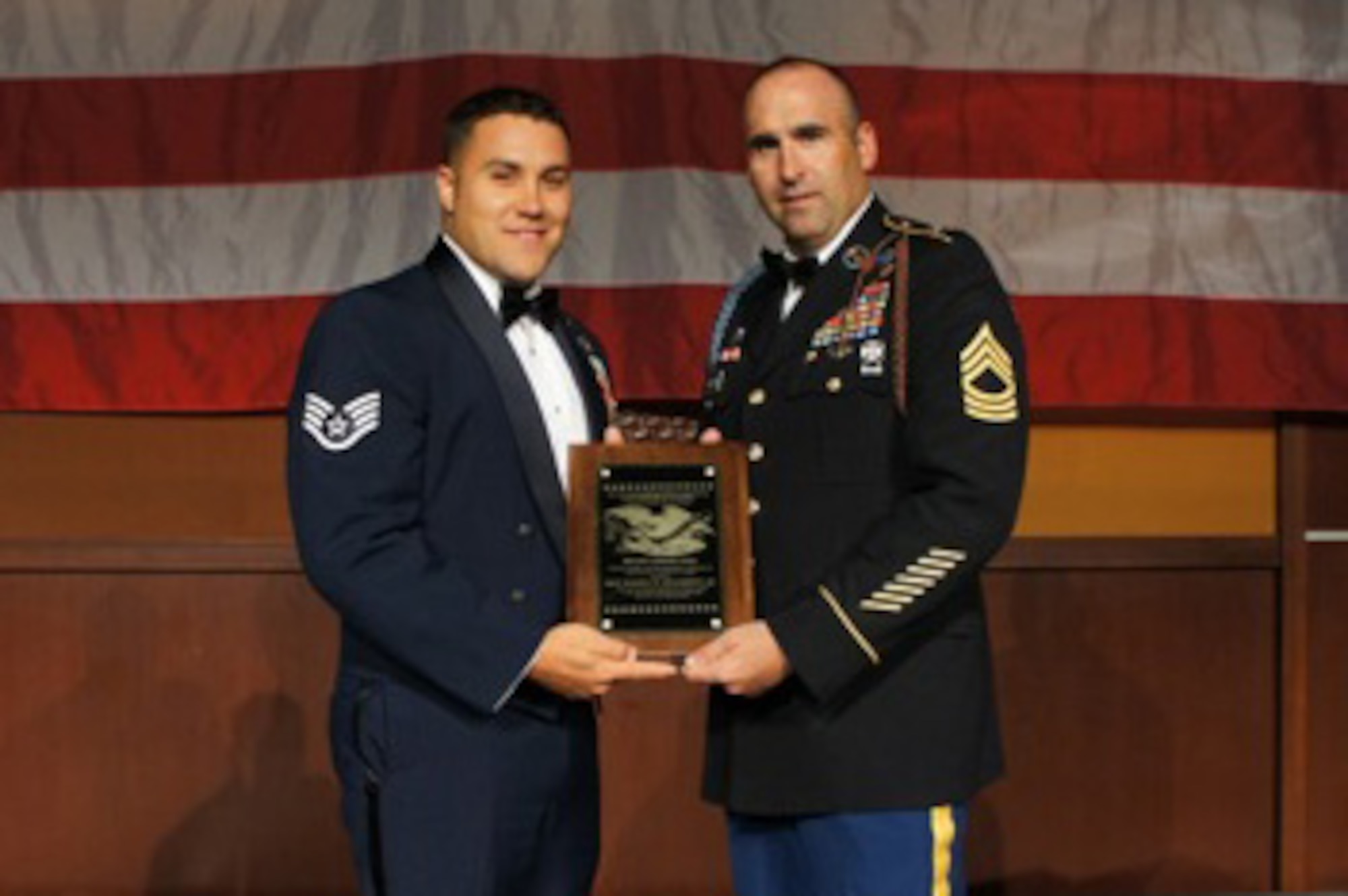 U.S. Air Force Staff Sgt. Warren Williamson Jr., a medic with the 18th Medical Operations Squadron, and U.S. Army Master Sgt. Chris Demars, 1st Battalion, 181st Infantry, pose with Williamson's Vanguard Award at the NCO Association 2012 Annual Convention in Las Vegas, Nev., July 12, 2012. Williamson received the award for his heroic actions that saved the life of Demars, Williamson's first sergeant during their deployment in Afghanistan last year. (Courtesy photo)
