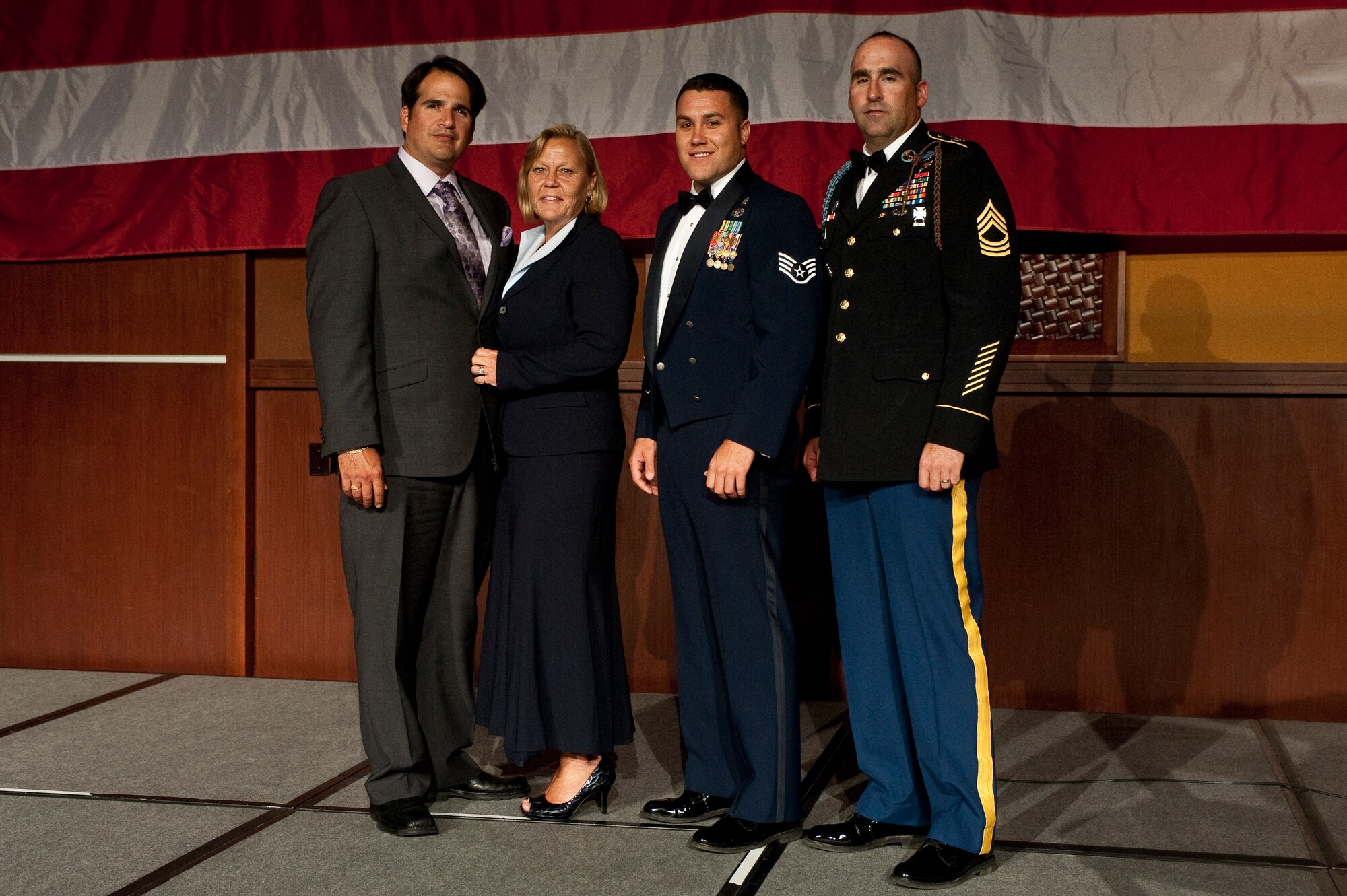 U.S. Air Force Staff Sgt. Warren Williamson, a medic with the 18th Medical Operations Squadron, poses with his mother, father and U.S. Army Master Sgt. Chris Demars, 1st Battalion, 181st Infantry, and first sergeant of Williamson’s deployed team after recieving the Vanguard Award during the Non-Commissioned Officer Association Vanguard Tribute Banquet July 12, 2012, in Las Vegas, Nev. The NCOA Vanguard Tribute Banquet allowed five U.S. Service Members from all five branches recognition for their heroic actions. (U.S. Air Force photo by Staff Sgt. Christopher Hubenthal)