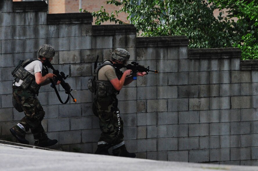 Staff Sgt. David Wessell (left) and Senior Airman Christopher Blake, both 51st Security Forces Squadron members, advance towards opposing forces during operational readiness exercise Beverly Midnight 12-03 at Osan Air Base, Republic of Korea, July 25, 2012. Throughout the week, Osan Mustangs demonstrate the ability to operate in a chemical environment as well as administer self-aid and buddy-care during a wartime environment. Airmen also highlight their ability to position, employ, and sustain forces and showcase operational readiness. (U.S. Air Force photo/Staff Sgt. Craig Cisek)