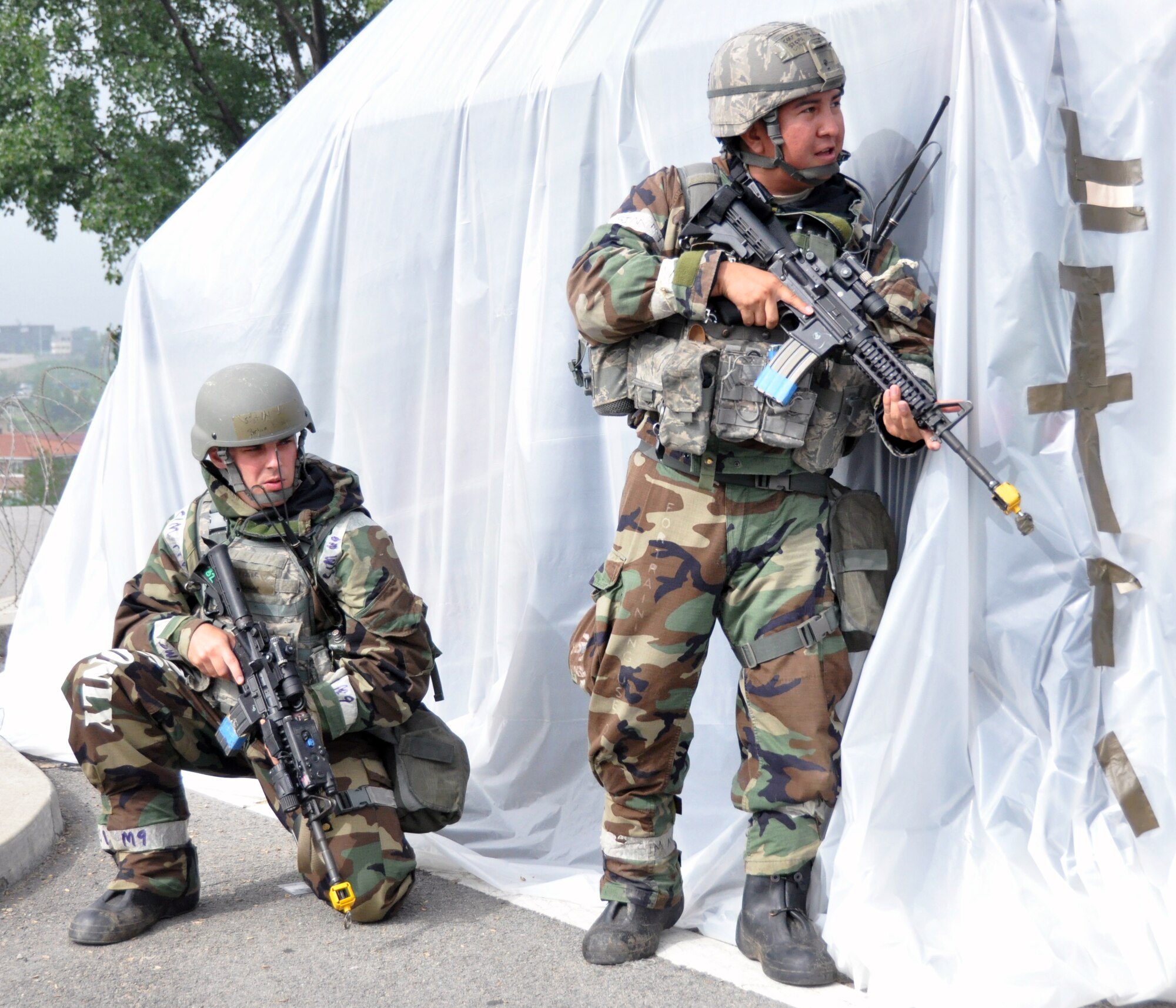Two members of the 51st Security Forces Squadron hold a defensive position against opposing forces during operational readiness exercise Beverly Midnight 12-03 at Osan Air Base, Republic of Korea, July 25, 2012. BM 12-03 is the fourth ORE for Team Osan in 2012. Throughout the week, Osan Mustangs demonstrate the ability to operate in a chemical environment as well as administer self-aid and buddy-care during a wartime environment. (U.S. Air Force photo/Senior Airman Michael Battles)
