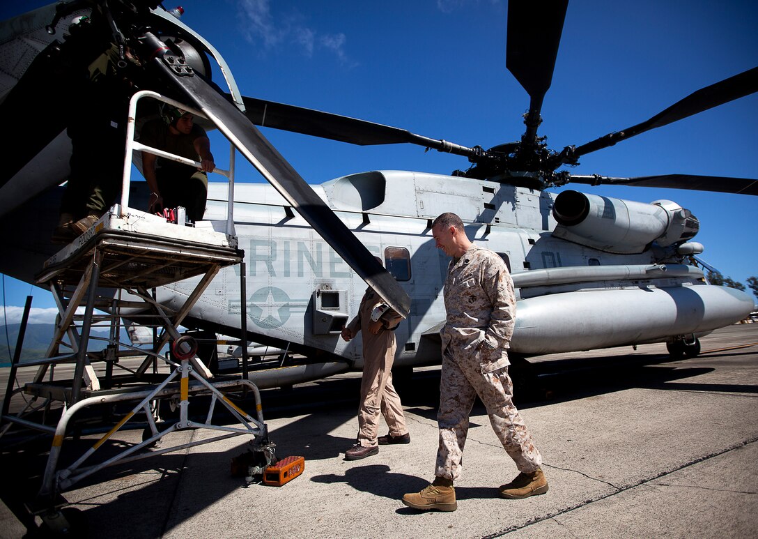 U.S. Marine Gunnery Sgt. Frank Dugger (right), the maintenance control chief for Marine Heavy Helicopter Squadron 463, jokes with Gunnery Sgt. Tony Davis (center), the HMH-463 quality assurance chief, while inspecting one of their squadron’s CH-53E Super Stallion helicopters on Marine Corps Air Station Kaneohe Bay, Hawaii, July 25, 2012. The 41-year-old native of Tallahassee, Fla., nearly died from two cardiac episodes while deployed to Afghanistan in 2009. Dugger used his second chance to turn his life around. He quit drinking, began eating more healthily and decided to complete a triathlon. Less than a year later, he completed an Ironman triathlon in Cozumel, Mexico. In total, he’s finished 9 marathons and 30 triathlons.