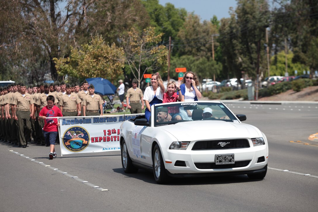 Colonel Christopher D. Taylor, commanding officer of the 13th Marine Expeditionary Unit and Grand Marshall of the Anaheim Independence Day Parade, and his family wave to the city residents as 13th MEU Marines and Sailors march down East Santa Anna Canyon Road, July 4, 2012. The 13th MEU Color Guard and a platoon-size formation of Marines and Sailors marched throughout the streets for the annual parade. The City of Anaheim adopted the unit in October 2007 and its Adoption Committee has since supported the MEU in numerous ways including, gift baskets for new parents, ball fundraising and their annual Christmas party.
(Official Marine Corps photo by Sgt. Christopher O’Quin/Released) 
