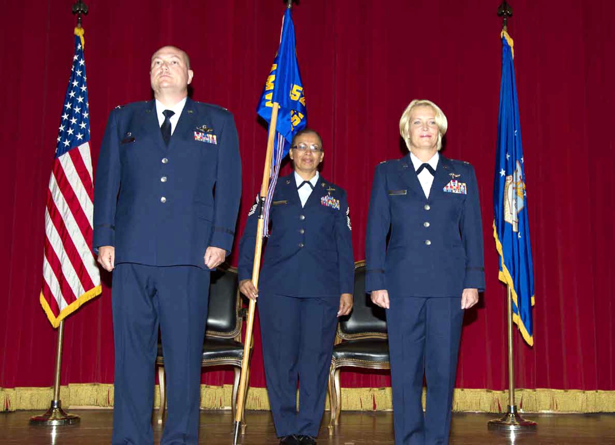 Lt. Col. Carolyn Newhouse, right, prepares to take command of the 452d Aeromedical Evacuation Squadron on July 21 during an assumption of command ceremony in the Cultural Resource Center. Col. Mark Sigler, left, 452d Operations Group commander, was the presiding officer for the event. Senior Master Sgt. Josephine Carrillo, 452d AES, holds the guidon which symbolizes the transfer of authority from the old to the new commander. (U.S. Air Force photo by/ Staff Sgt. Matthew Smith)

