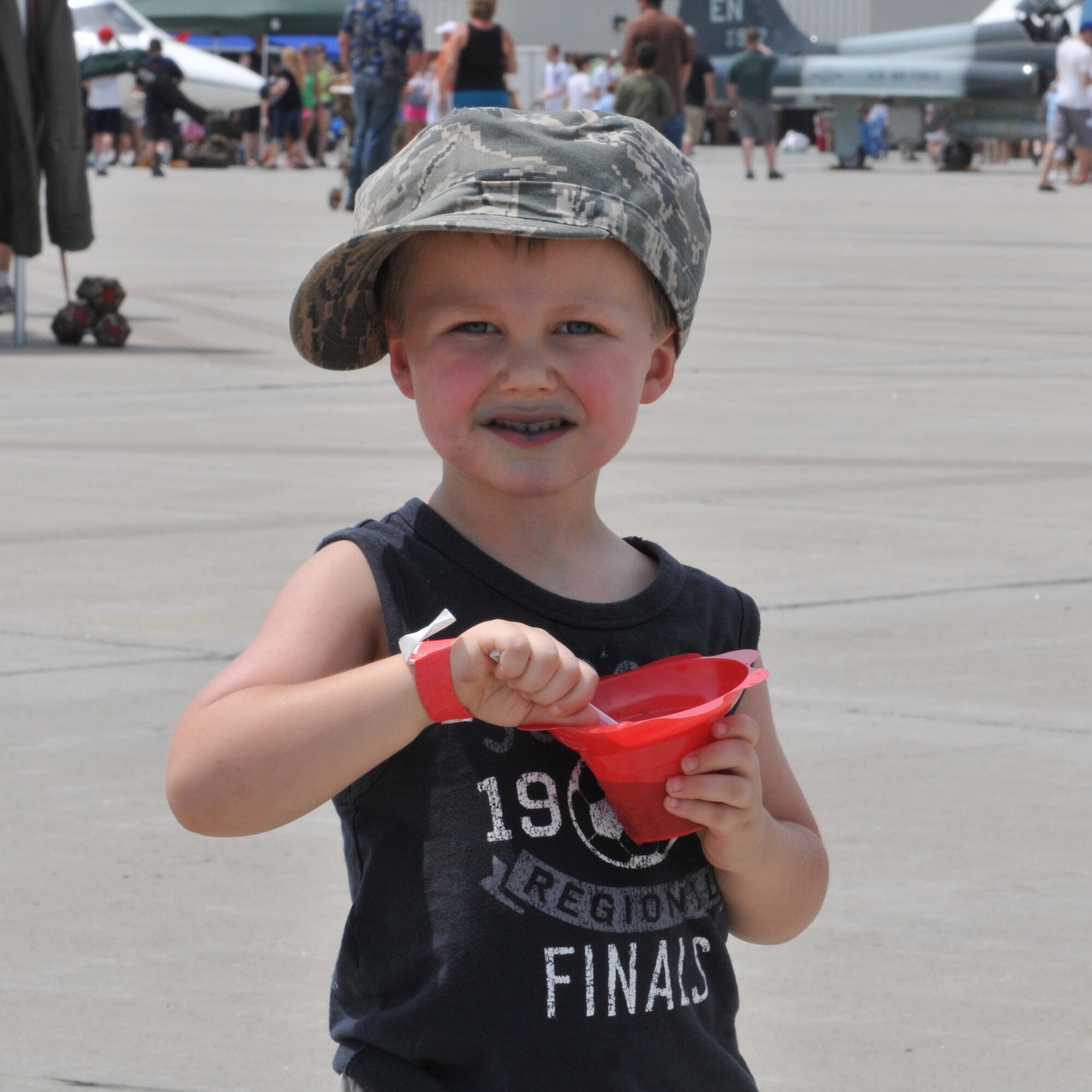 SIOUX FALLS, S.D. - Parker Stewart, son of Master Sgt. Christopher Stewart, 114th Public Affairs photographer, cools off with a  snow cone during Sioux Falls Airshow 2012. The 114th Fighter Wing hosted the airshow in conjuction with the city and also used the day as Family Day for it's units members and families.(National Guard photo by Master Sgt. Christopher Stewart)(Released)