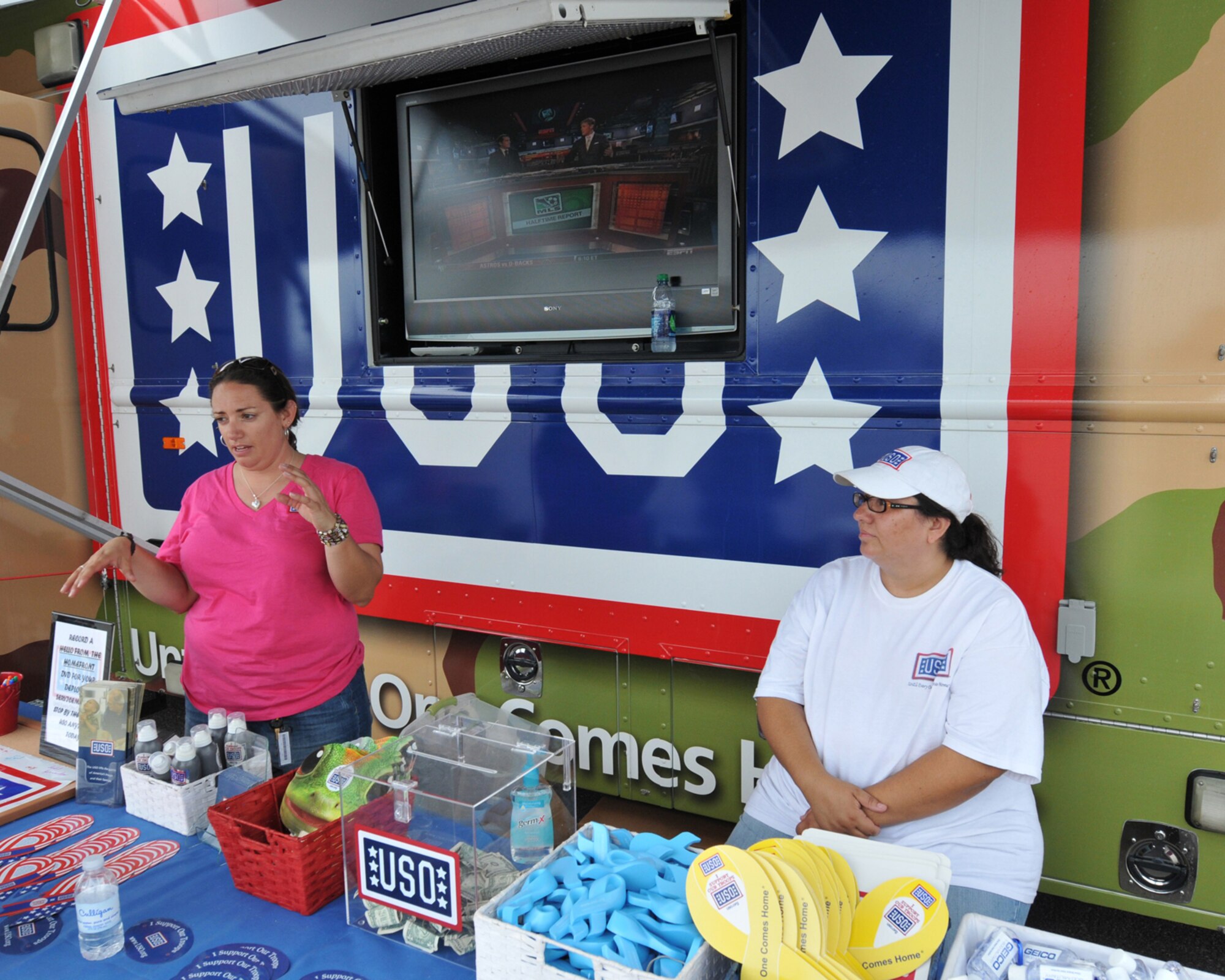 SIOUX FALLS, S.D. - Leigh Edmonds (left), Mobile Program Manager and Eva Gonzalez, Mobile Canteen and Volunteer Coordinator, staff their mobile United Services Organization vehicle here July 21.  One of only three mobile USO's in the country, the unit visited here during Sioux Falls Airshow 2012.(National Guard photo by Master Sgt. Christopher Stewart)(Released)