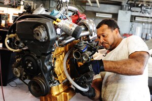 U.S. Army Sgt. 1st Class Michael Daniel, a car enthusiast, attaches a mount to his custom-made engine July 12 at the Langley Air Force Base, Va., auto hobby shop. The auto hobby shop provided all of the tools Daniel needed for the job, including the engine hoist. (U.S. Air Force photo by Airman 1st Class Austin Harvill/Released)