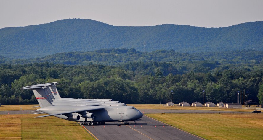 Four C-5s have been temporarilty relocated to a taxiway by the "Dogpatch" training area to make room for the Air Show aircraft. The Holyoke mountain range, also pictured, is an historical part of Westover's Strategic Air Command era -- from 1958 to 1970, a SAC command bunker was located within Bare Mountain, located in nearby South Hadley. (U.S. Air Force photo/SrA. Kelly Galloway)