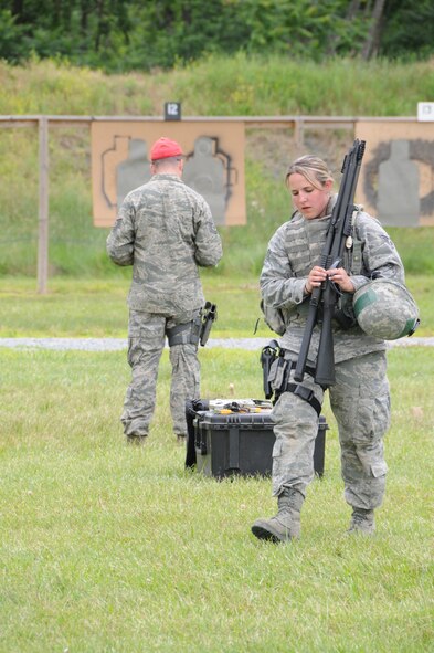 Senior Airman Nyrel Shearer carries M870 shotguns after her and other members of the 193rd Special Operations Security Forces Squadron fired them in June during their annual training. Weapons qualification was part of a week-long annual training held at Fort Indiantown Gap, Annville, Pa.  (Photo by: Air National Guard Photographer, TSgt Culeen Shaffer)
