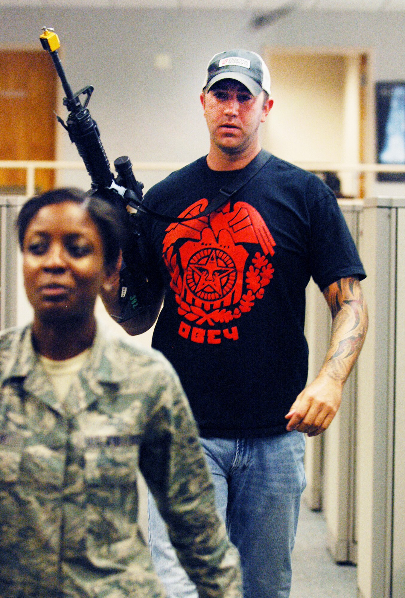 A simulated shooter leads a hostage away from her desk to a holding area during an exercise at Robins Thursday.  The exercise included a multi-agency collaboration with Robins Air Force Base, deputies from the Houston County Sheriff's Department and Georgia Bureau of Investigations agents. (U. S. Air Force photo/Sue Sapp)