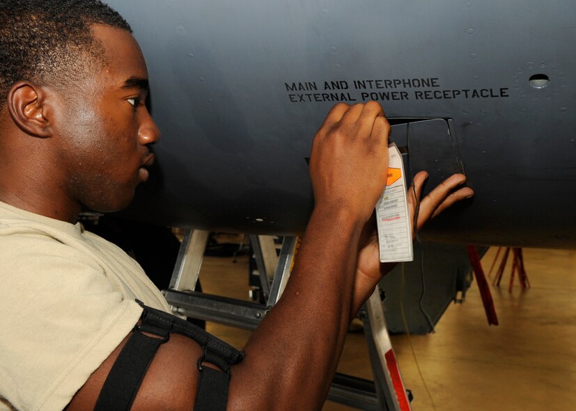 Airman 1st Class Javaris Wise, 2nd Maintenance Squadron non-destructive inspection apprentice, places a warning tag on the external power receptacle of a B-52H Stratofortress on Barksdale Air Force Base, La., July 25. Wise placed the warning tag on the B-52H to show others maintainers that work was being done in an electrical area and they should not engage power to the aircraft. (U.S. Air Force photo/Airman 1st Class Joseph A. Pagán Jr.)(RELEASED)