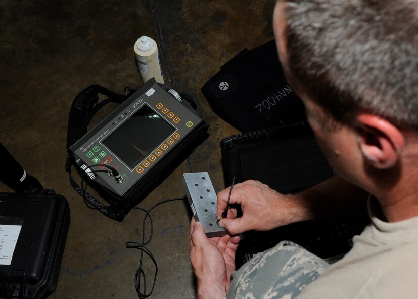 Tech. Sgt. Stacy McAteer, 2nd Maintenance Squadron non-destructive inspection assistant shop chief, sets up a USN60 ultrasonic unit on Barksdale Air Force Base, La., July 25. McAteer set up the USN60 to inspect the 694 bulkhead located in a crawl space above the bomb bay of a B-52H Stratofortress aircraft. The USN60 uses sound waves to detect cracks on parts of aircraft. (U.S. Air Force photo/Airman 1st Class Joseph A. Pagán Jr.)(RELEASED)